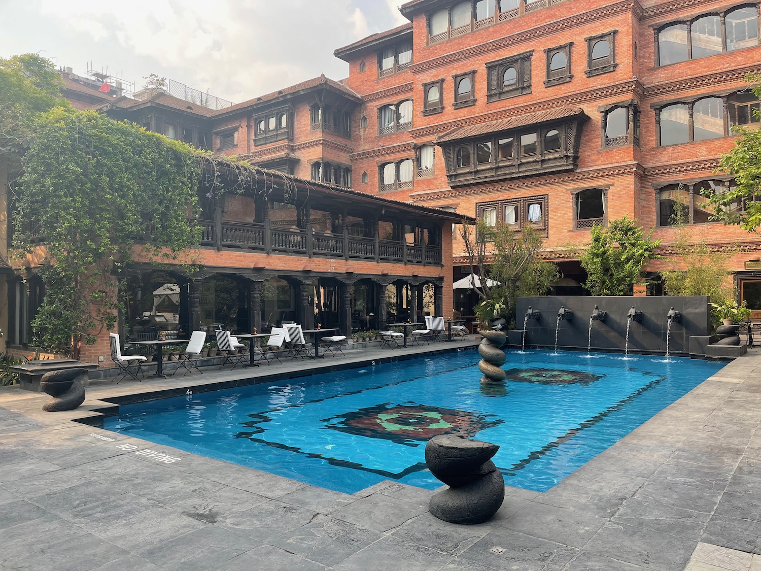 a pool with a stone sculpture in the middle of it