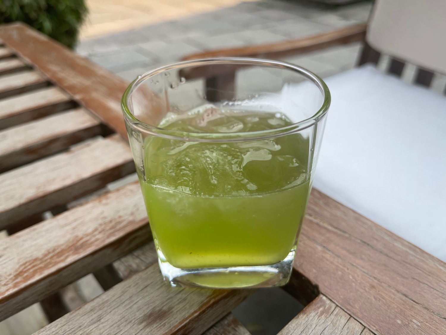 a glass of green liquid on a wooden table