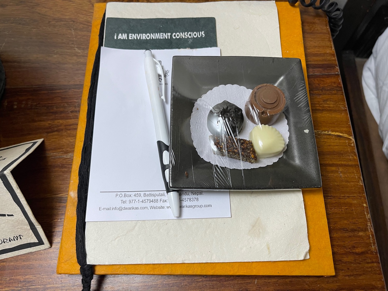 a plate of chocolates and a pen on a pad