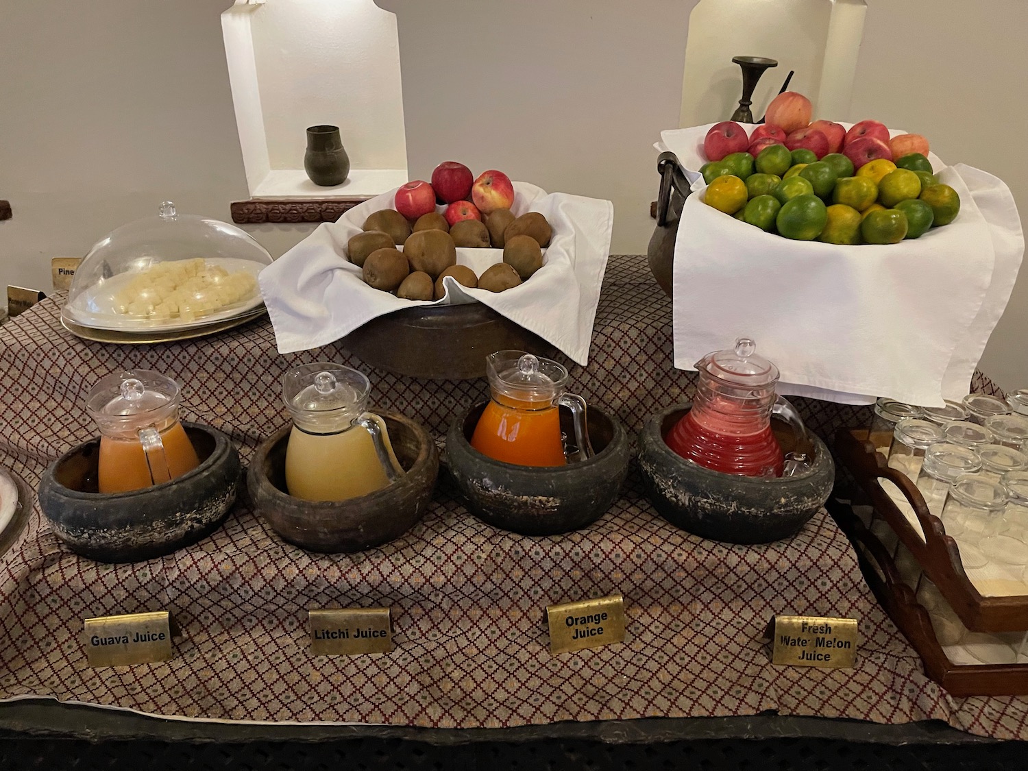 a table with bowls of fruit and juice