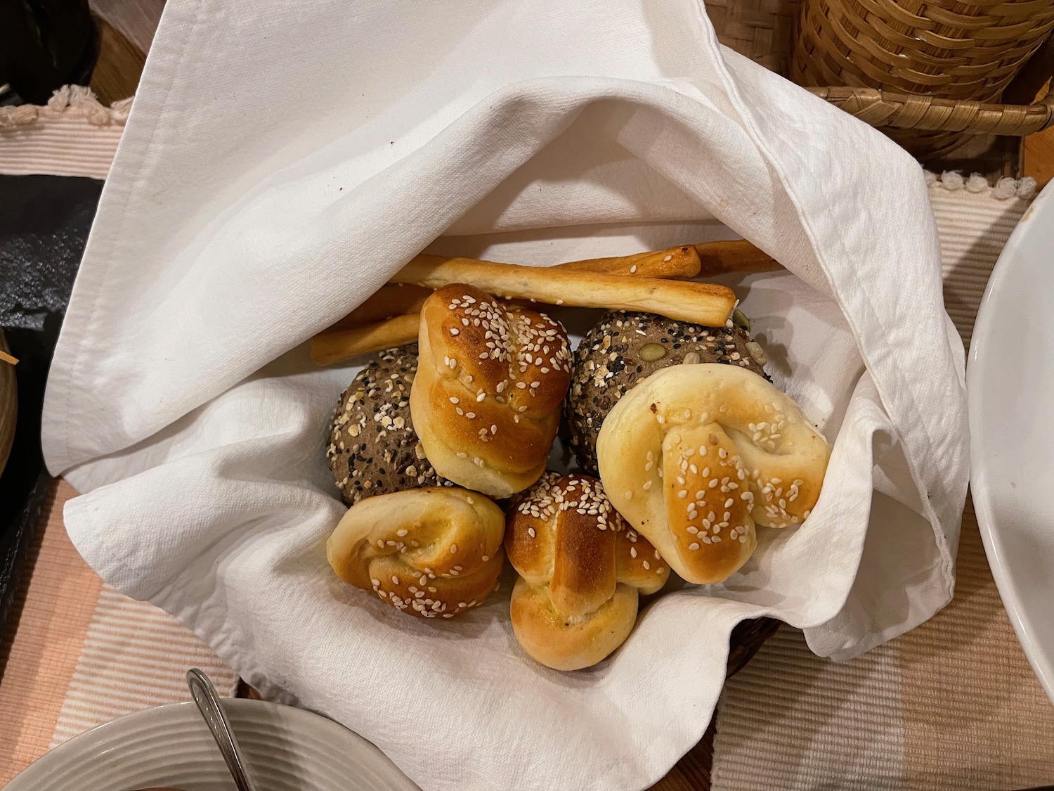 a basket of bread rolls and bread sticks