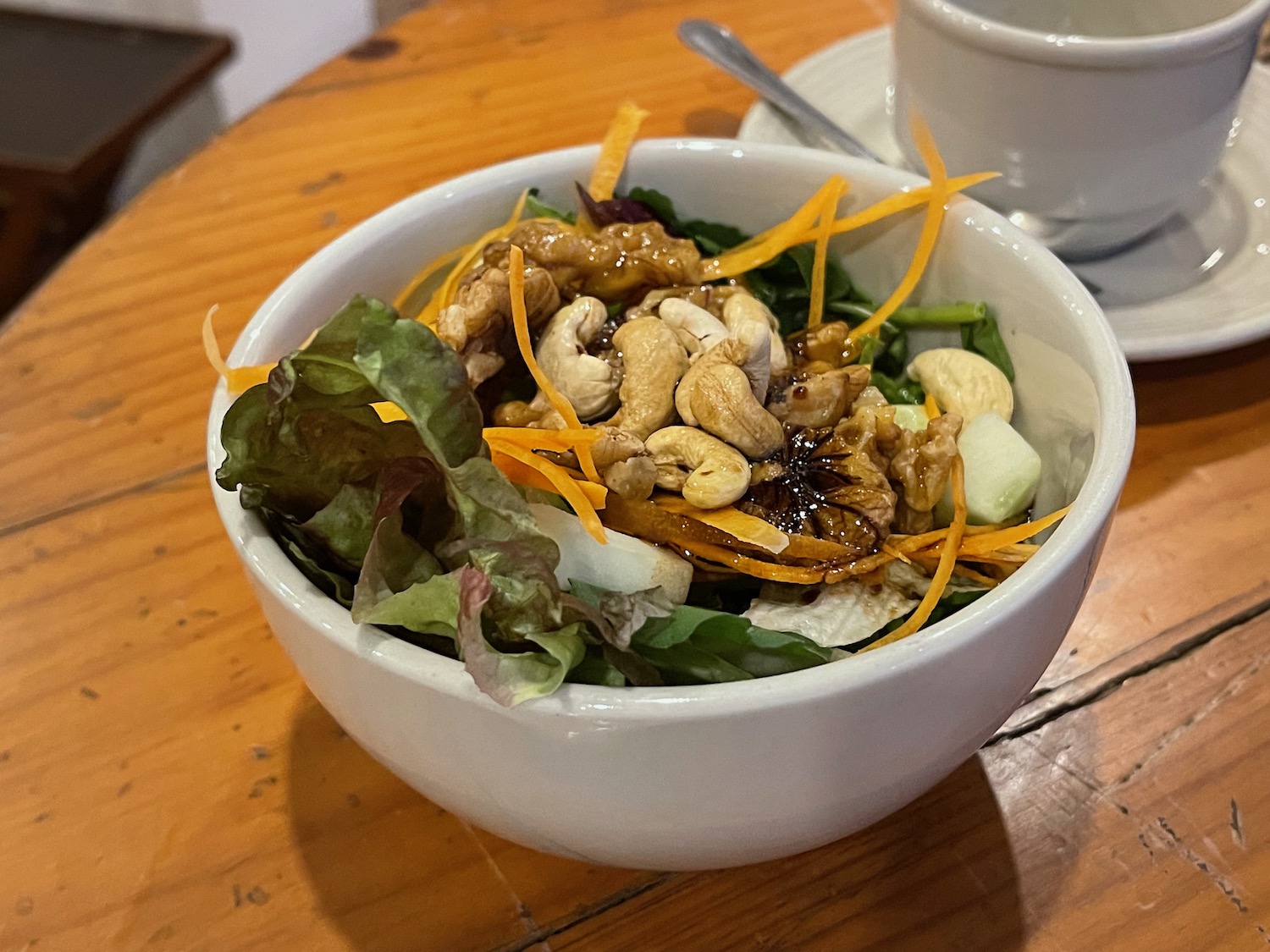 a bowl of salad with nuts and vegetables