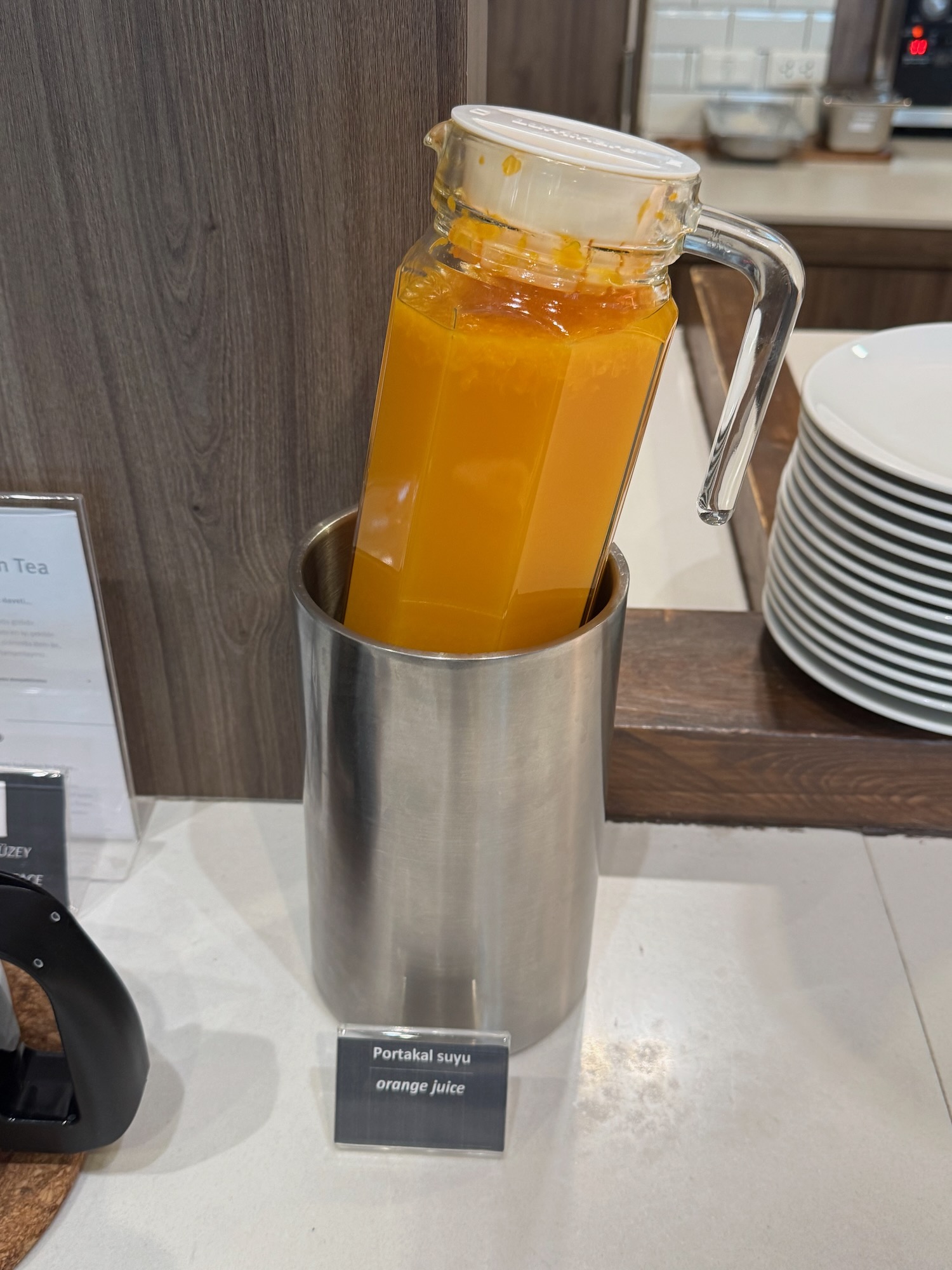 a glass jar with orange liquid inside of a metal container