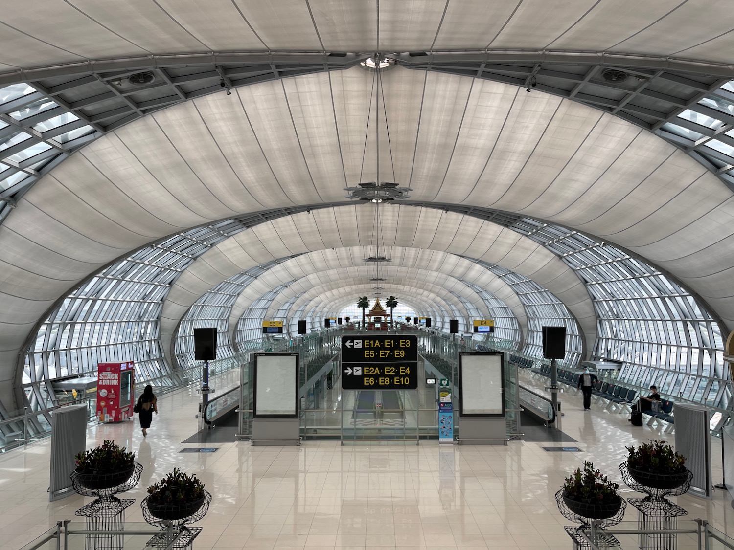 a large white and glass tunnel with people walking in it