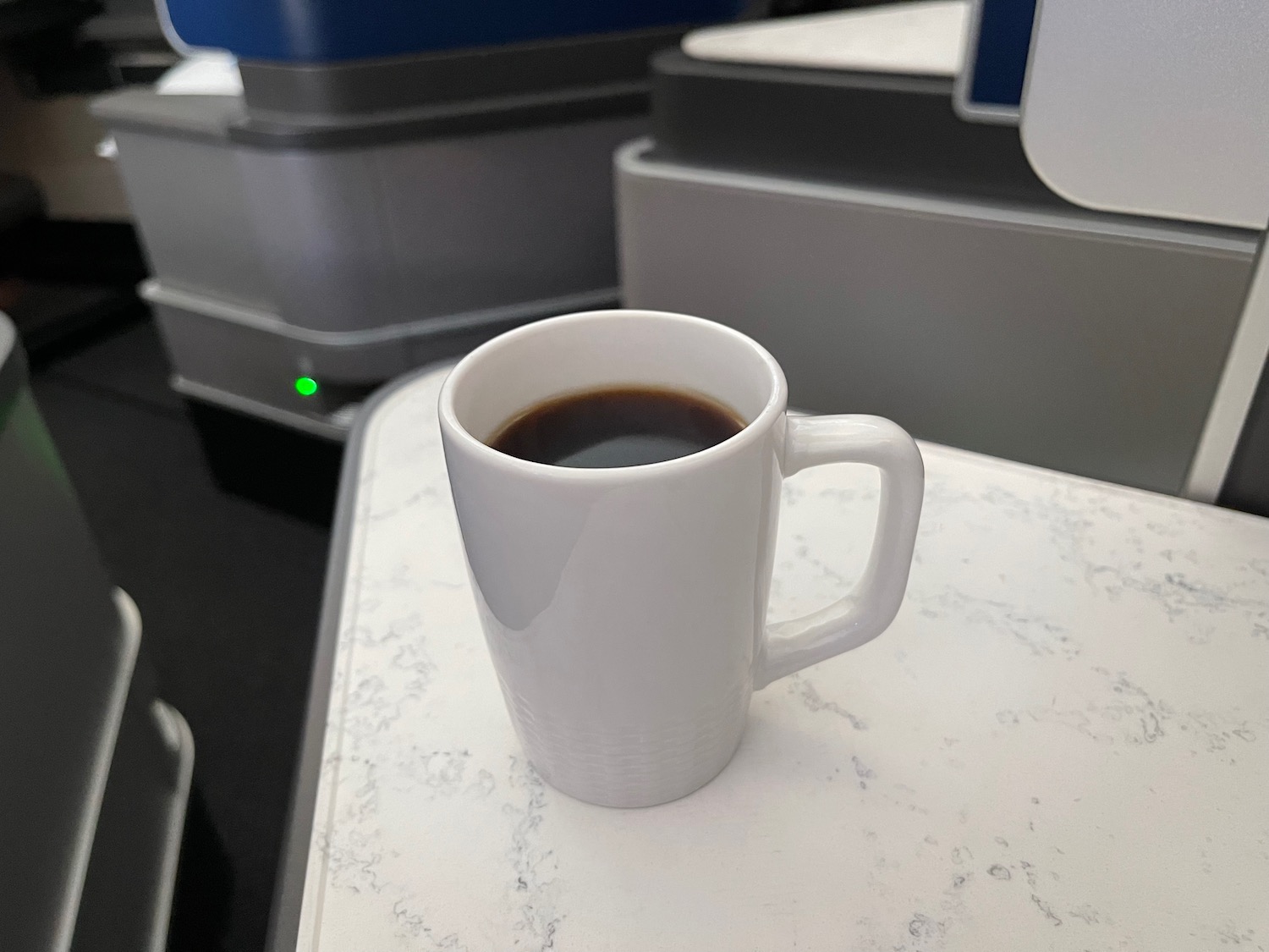 a white mug with a brown liquid on a table