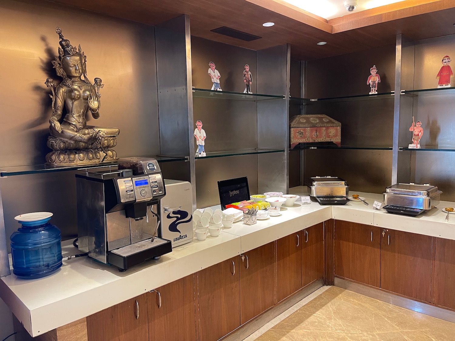 a kitchen with a counter top and shelves with a statue of a buddha