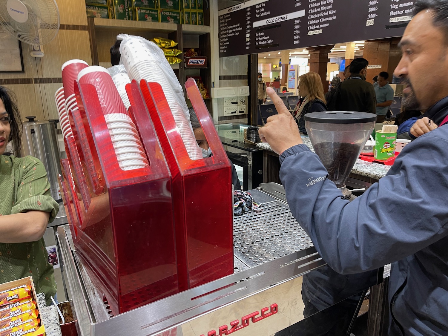 a person pointing at a stack of cups