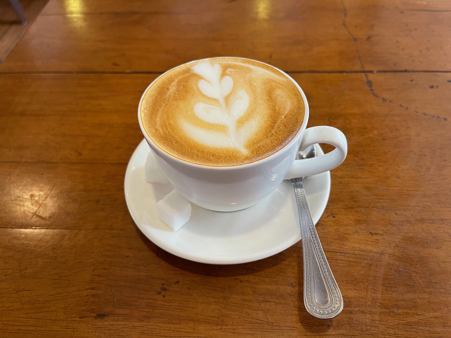 a cup of coffee with a leaf design on top of it