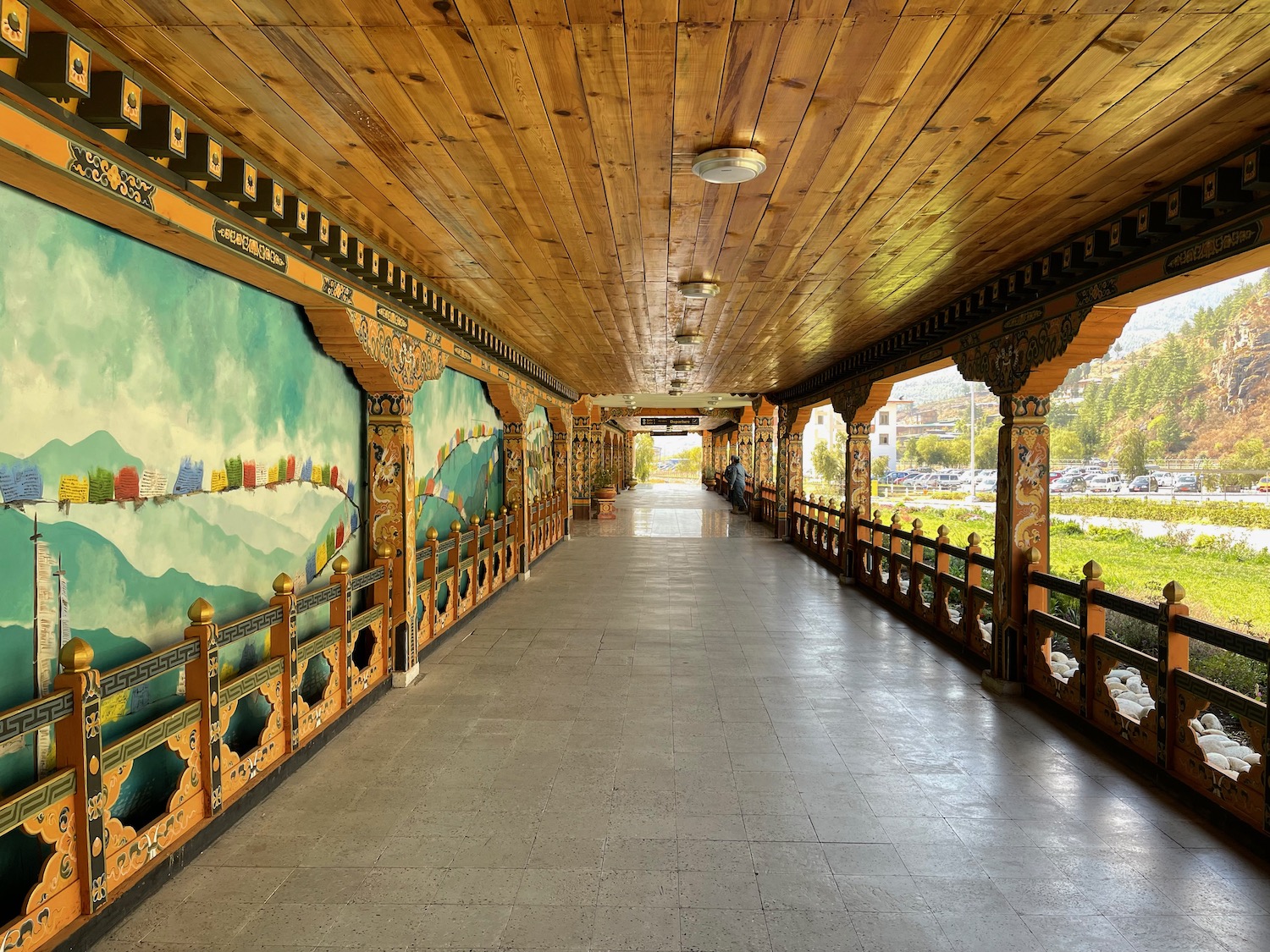 a long walkway with a painting on the wall