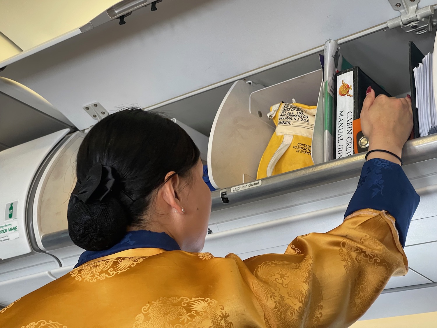 a woman in a yellow robe opening a shelf