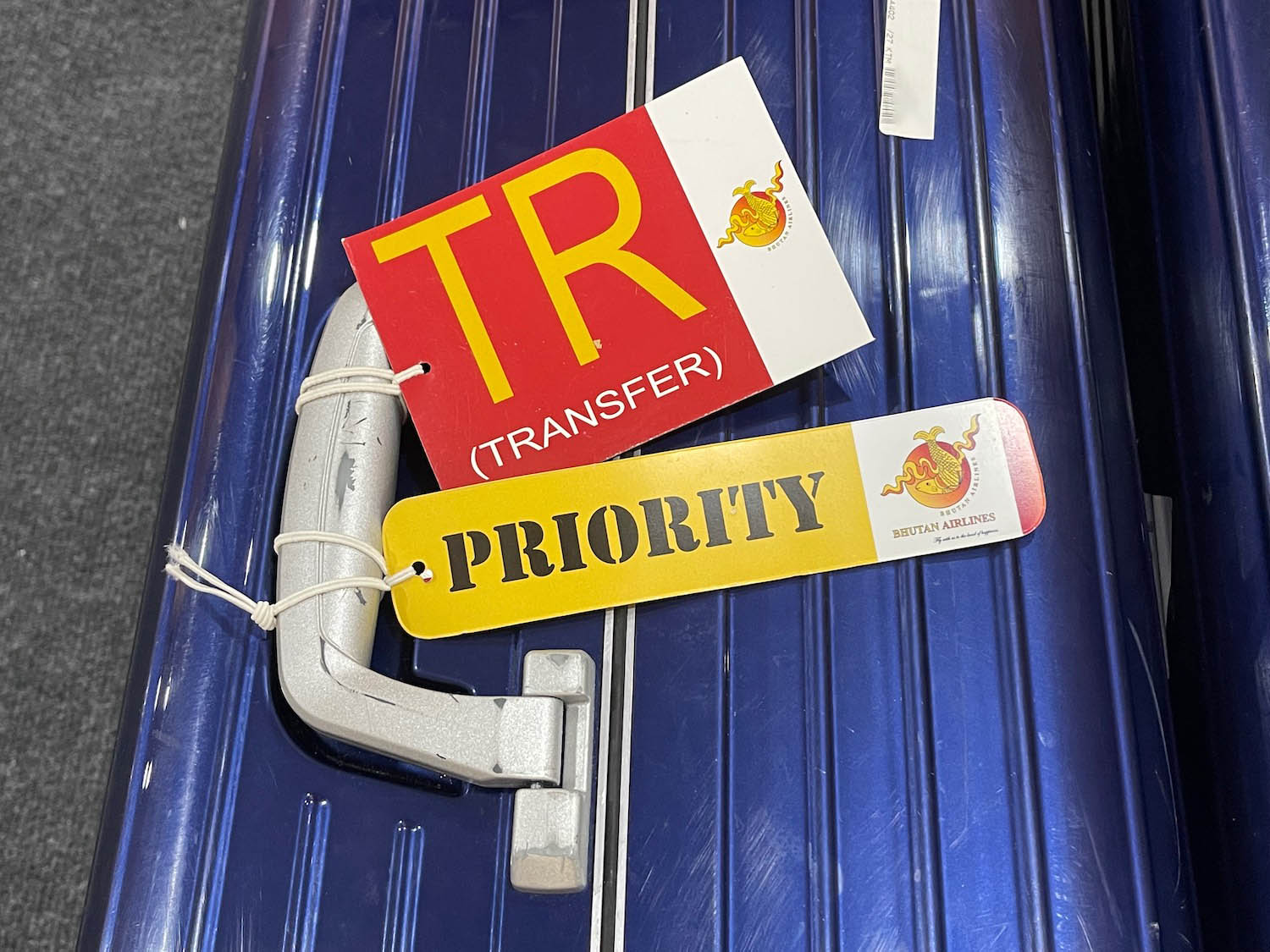 a blue suitcase with a red and yellow tag on it