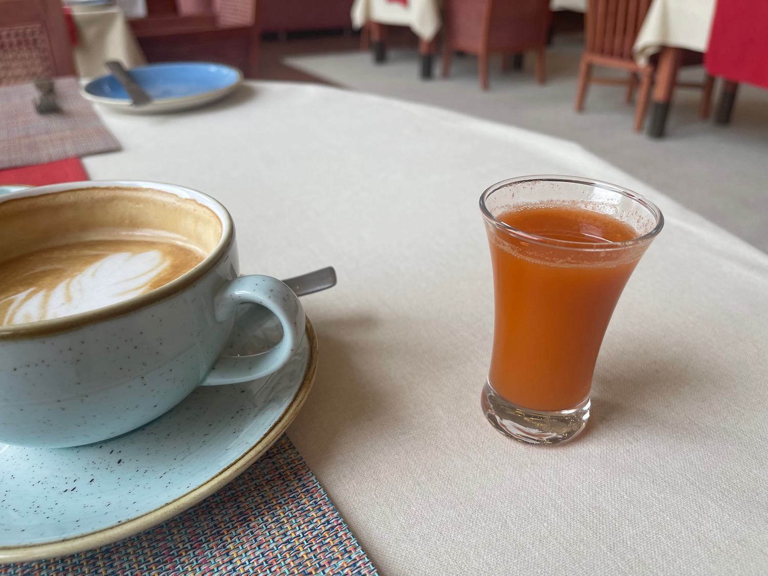 a cup of coffee and a glass of orange juice on a table