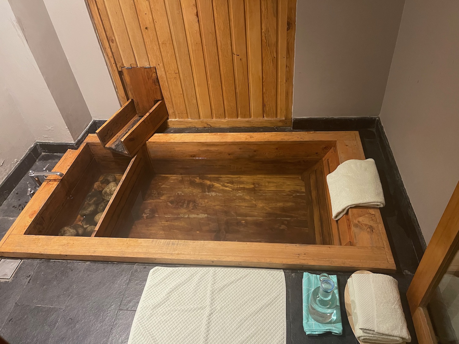 a wooden tub with rocks and towels