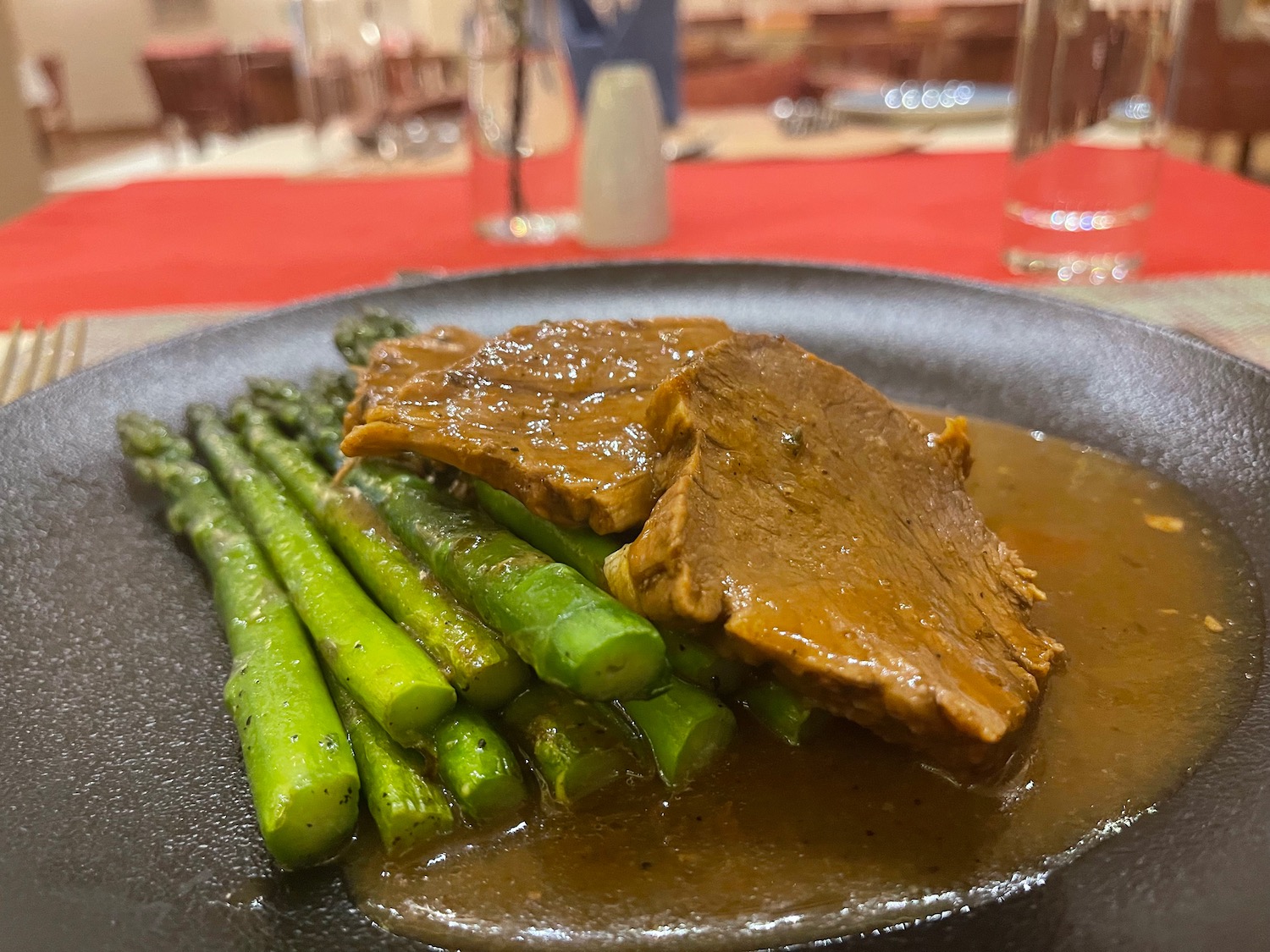 a plate of food with meat and asparagus