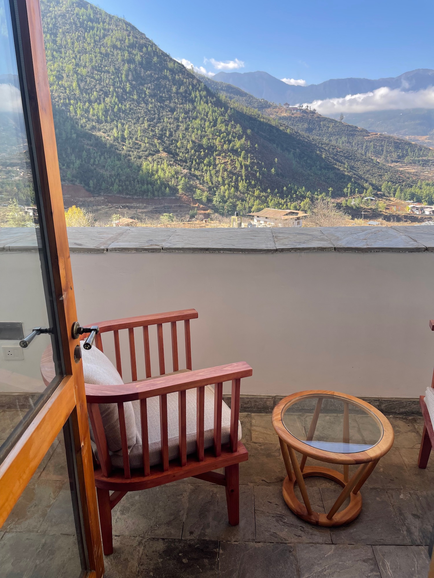 a chair and table outside with mountains in the background