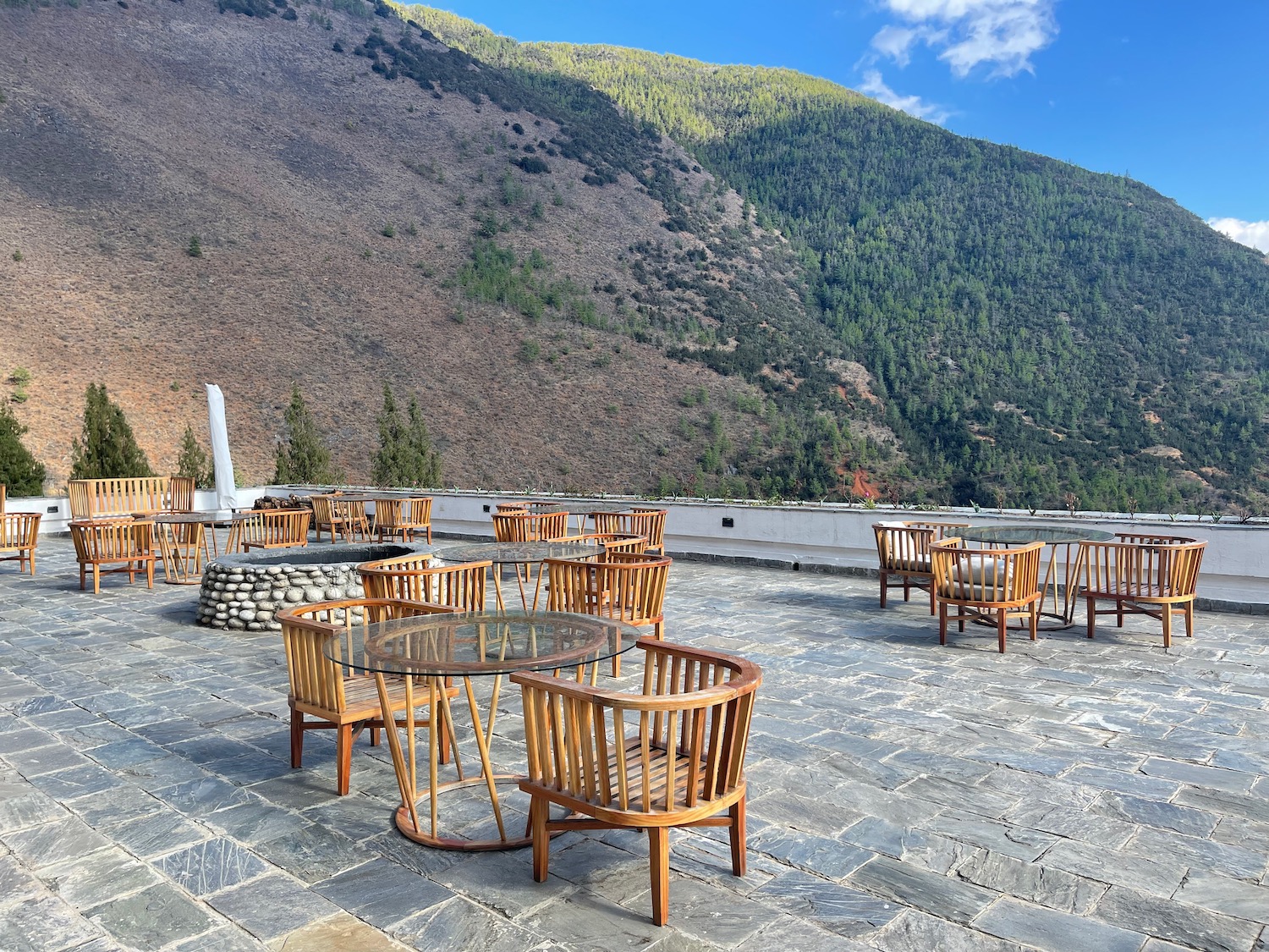 a patio with chairs and tables on a stone surface