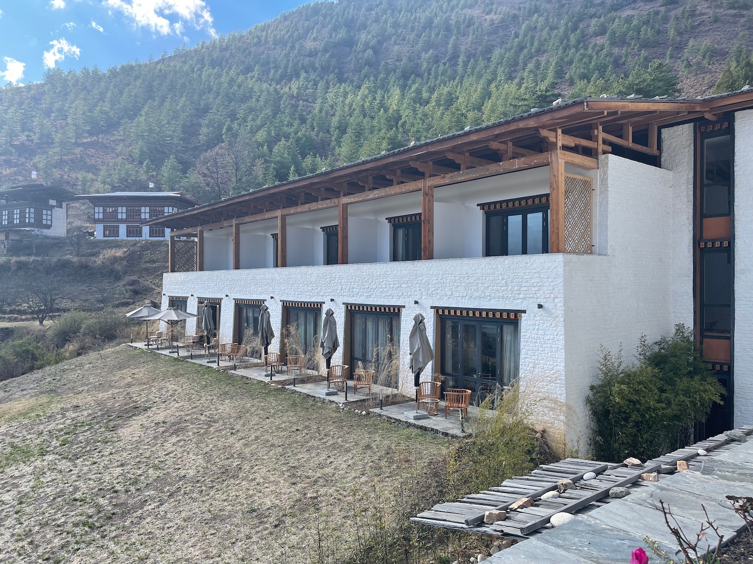 a building with a roof and chairs on the side