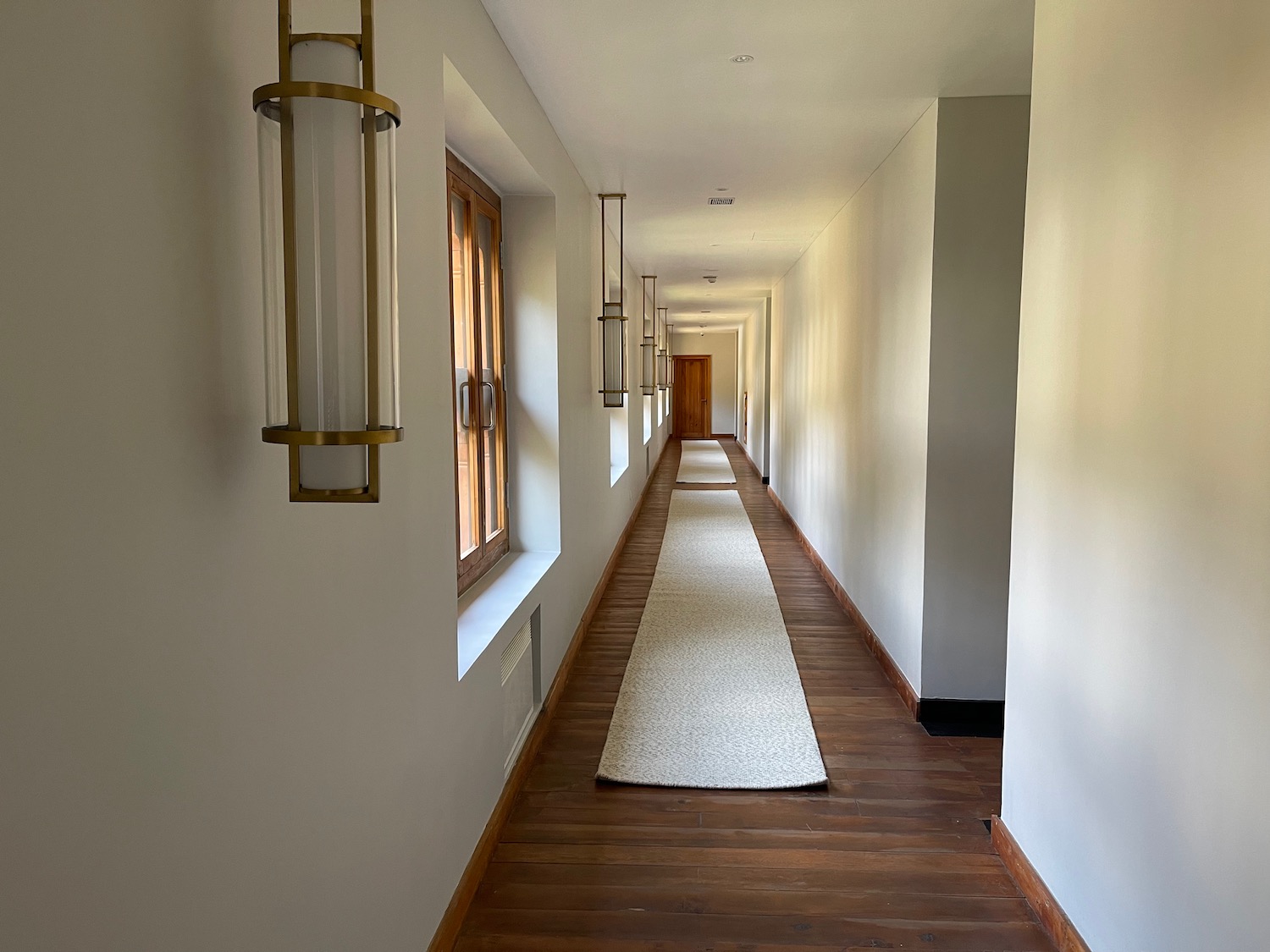 a long hallway with a white carpet and a wood floor