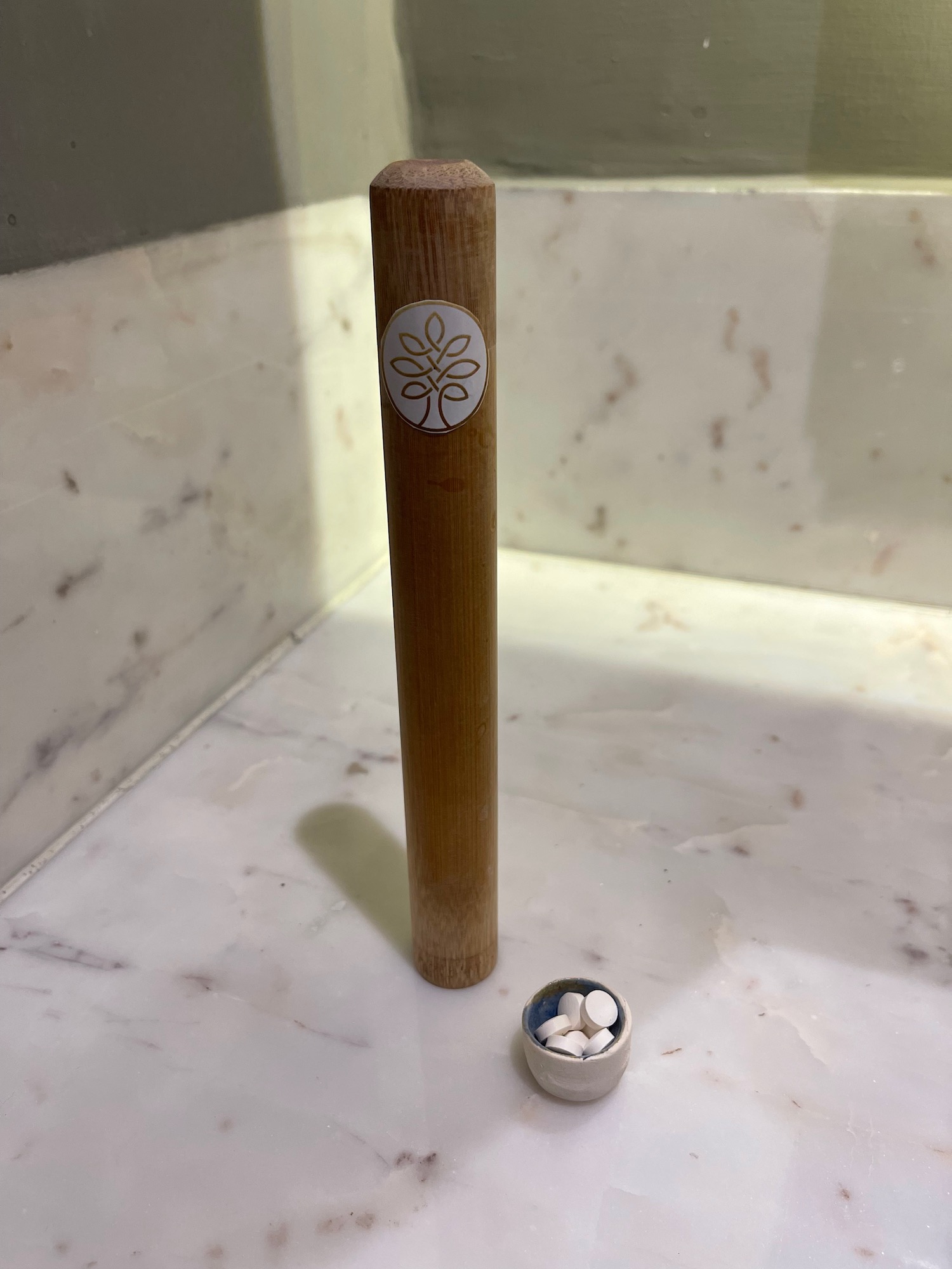 a wooden stick with a small container of pills