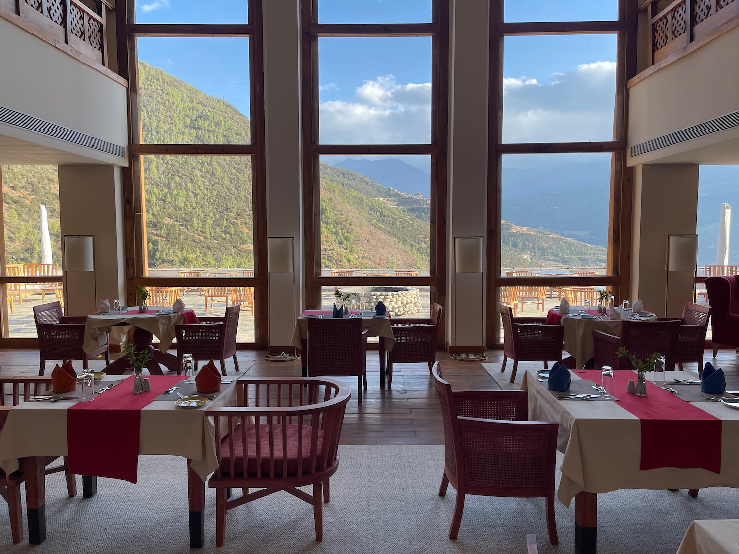 a room with tables and chairs and a view of mountains