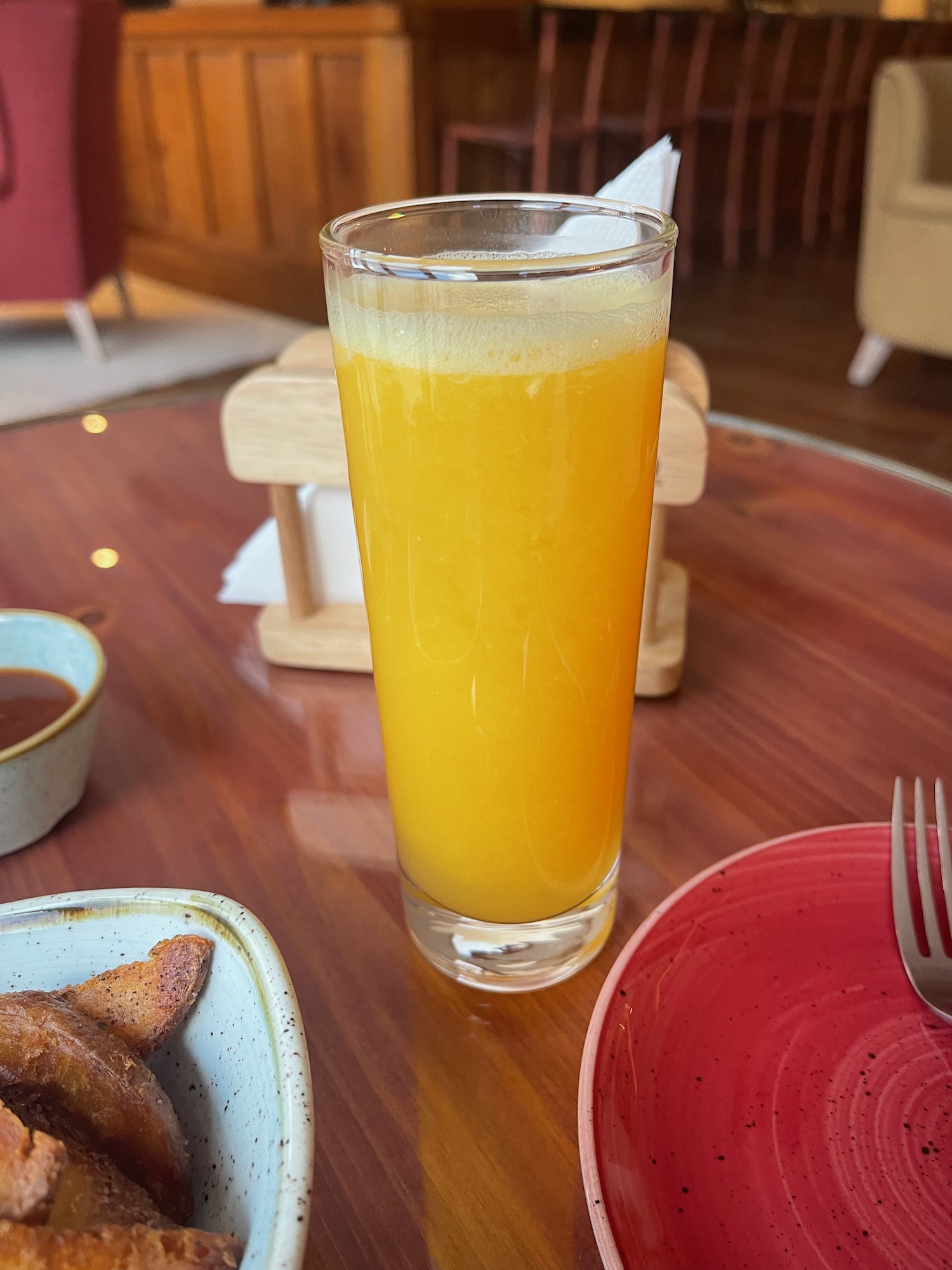 a glass of orange juice next to a plate of food