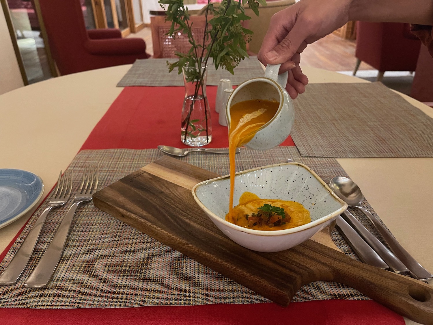 a person pouring soup into a bowl