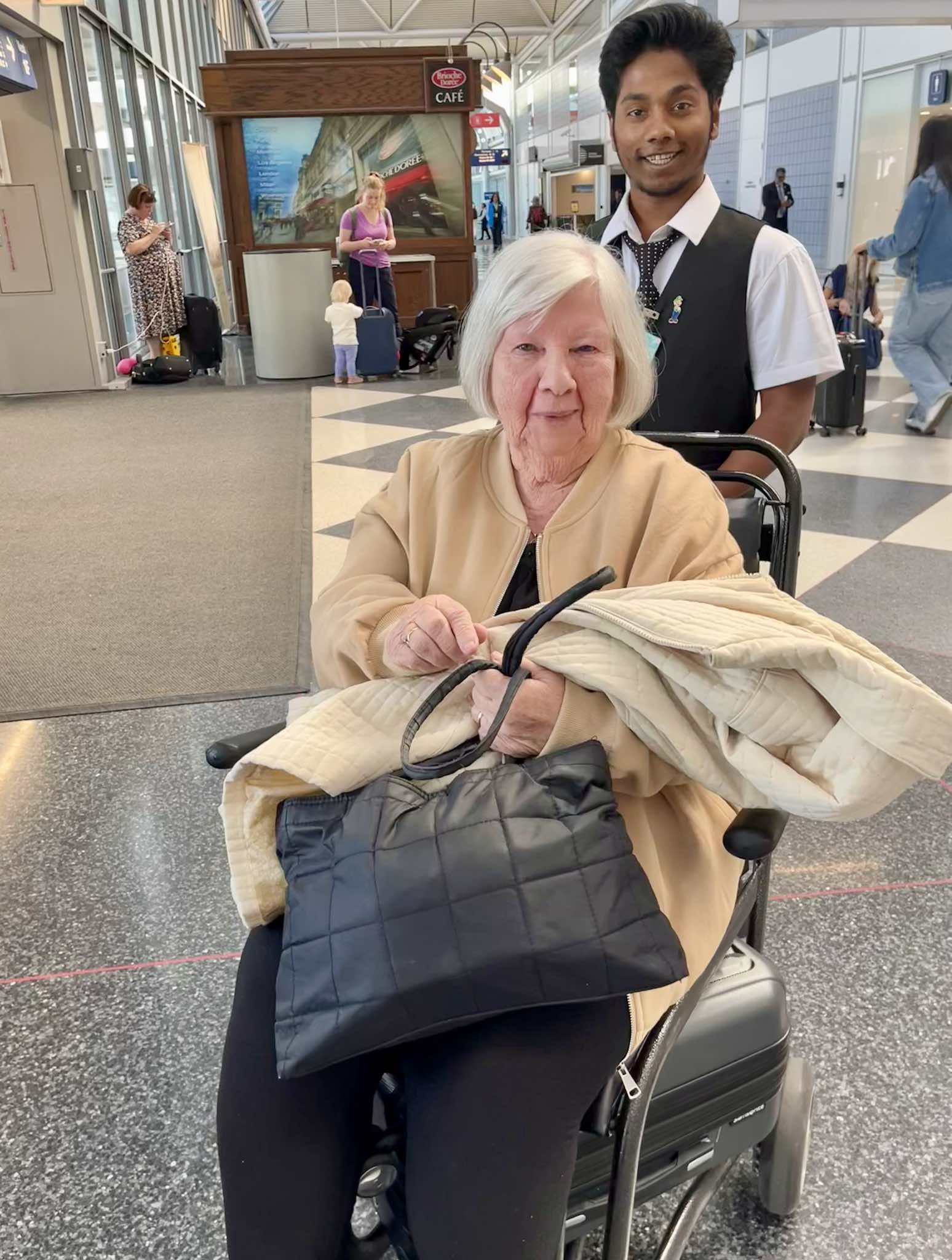 a woman in a wheelchair with a man behind her