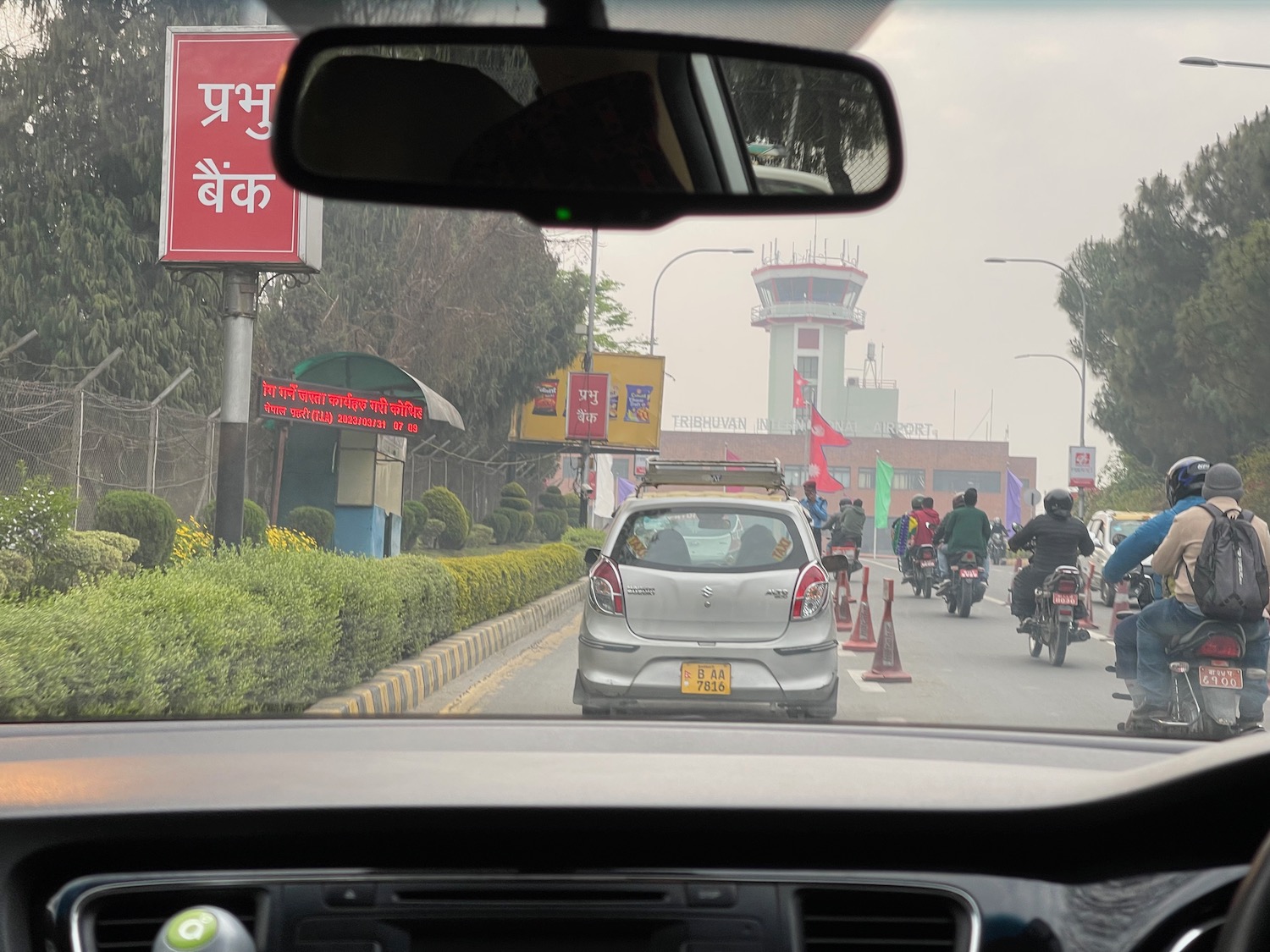 a car window with a view of a street with people and cars