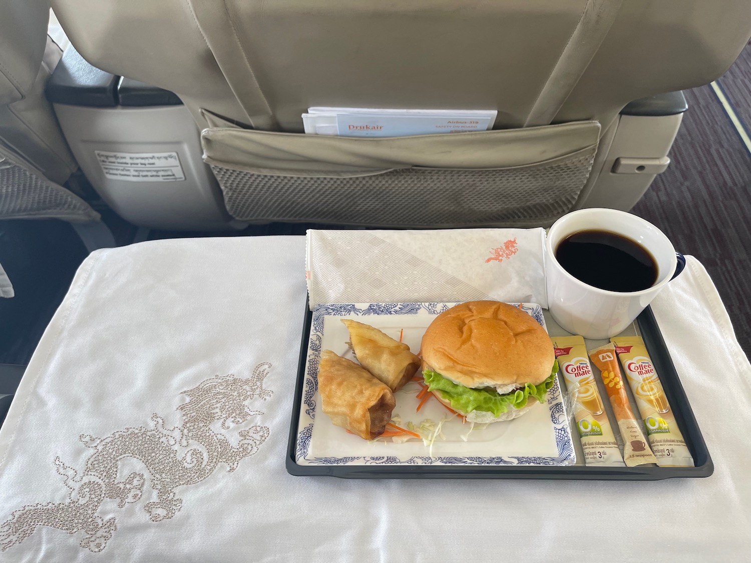 a tray of food and a cup of coffee on a table