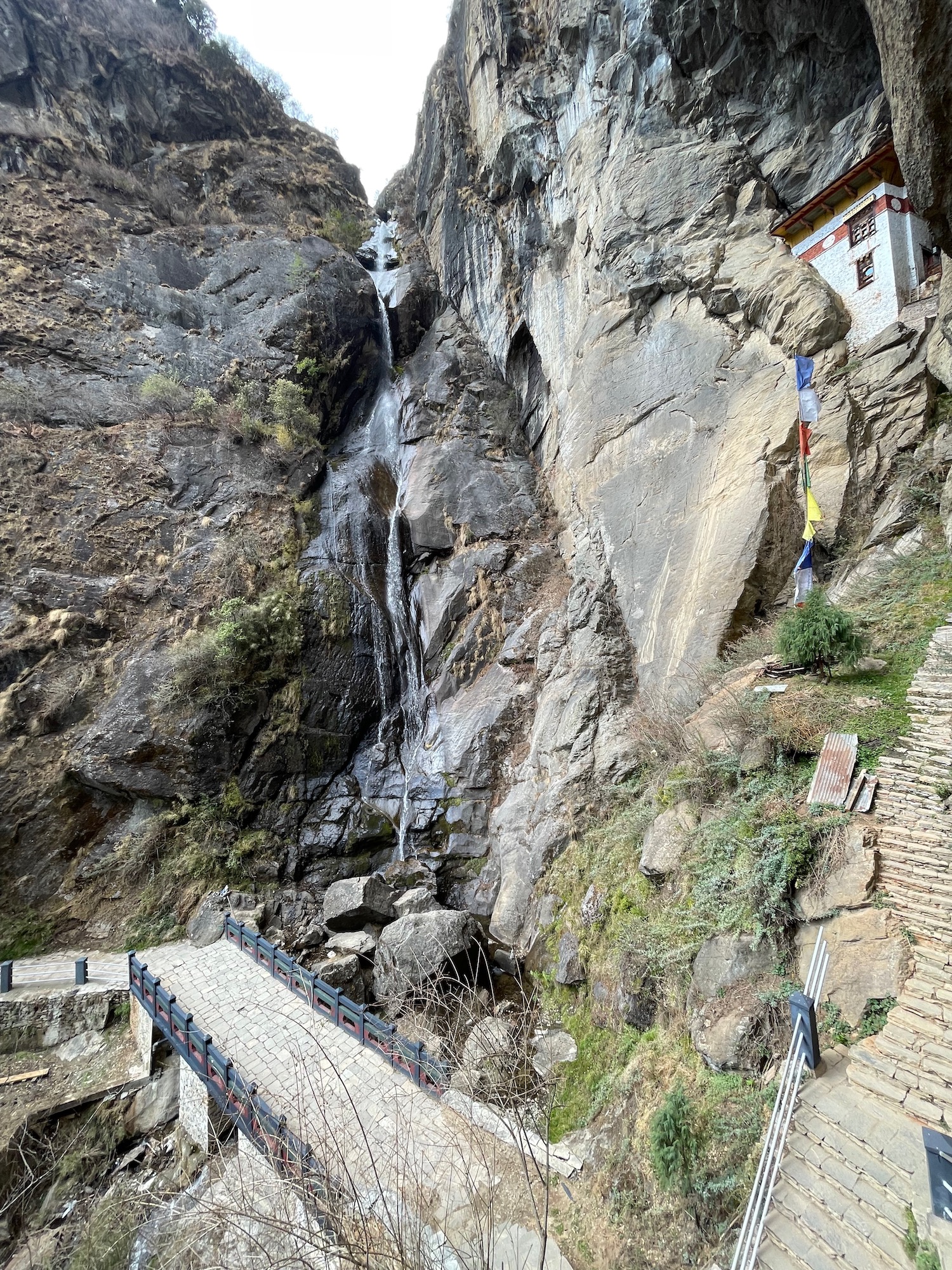 a bridge over a cliff with a waterfall