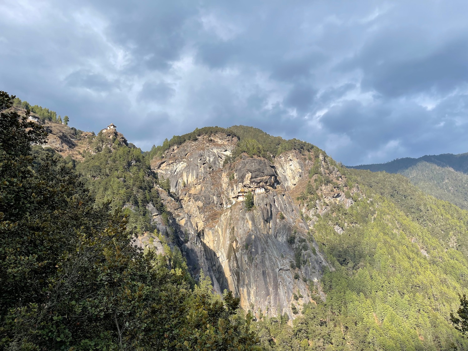 a mountain with trees and clouds