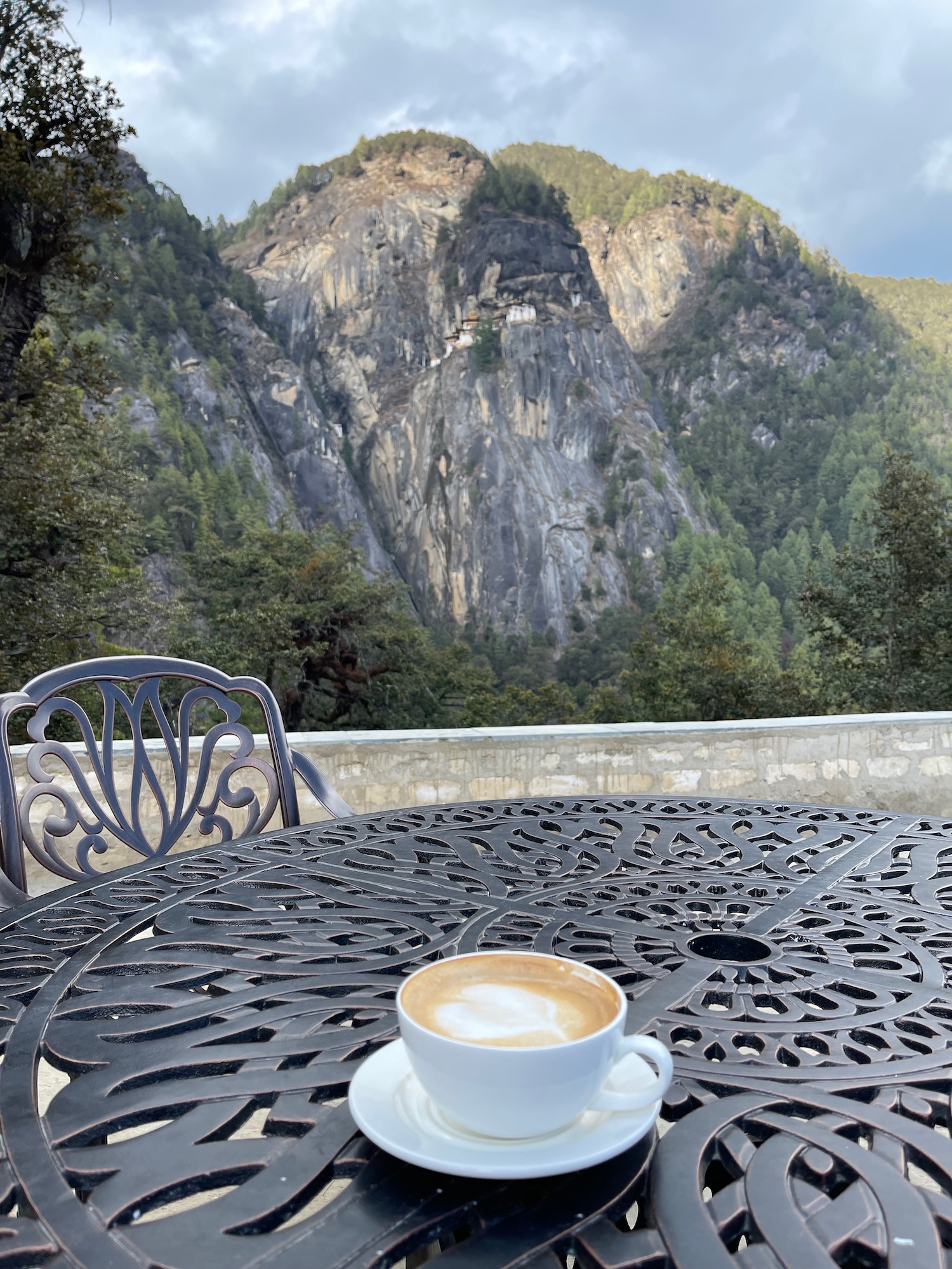 a coffee cup on a table with a mountain in the background