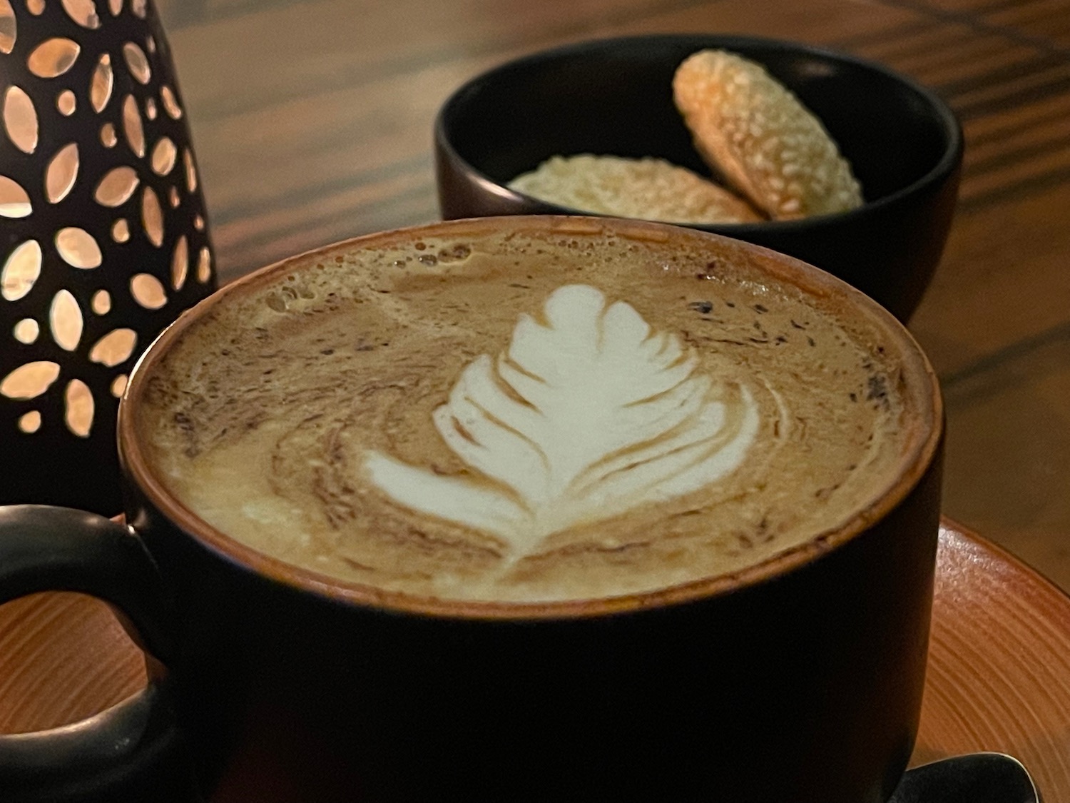 a cup of coffee with a leaf design in the foam