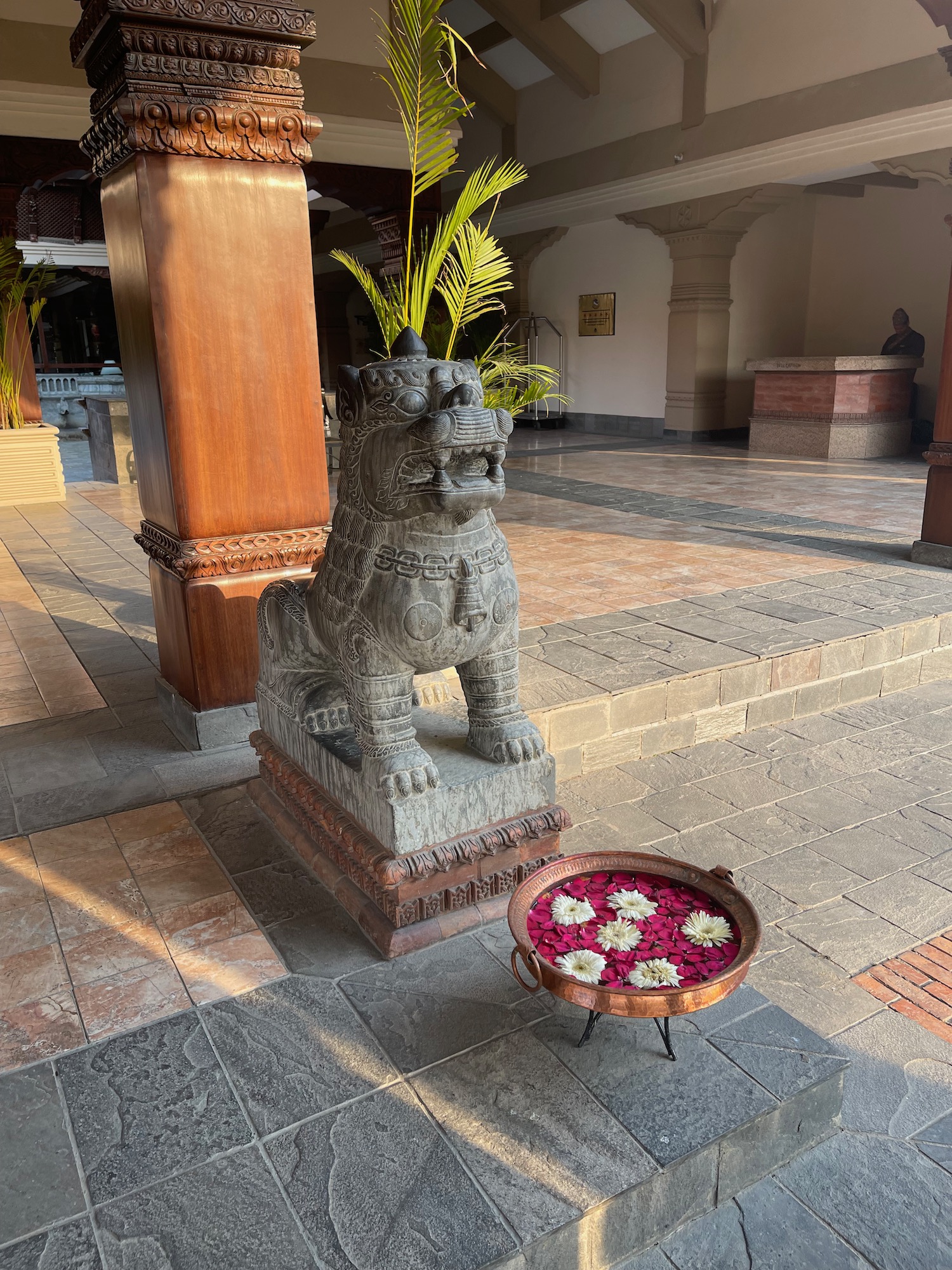 a statue of a lion with flowers in a bowl