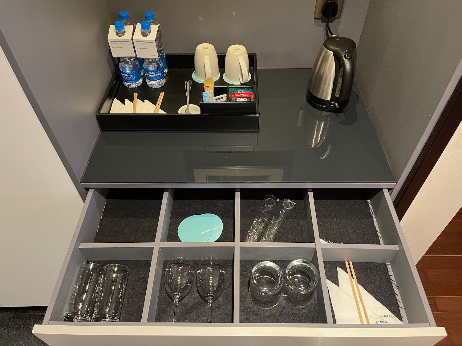 a drawer with a tray of glasses and cups