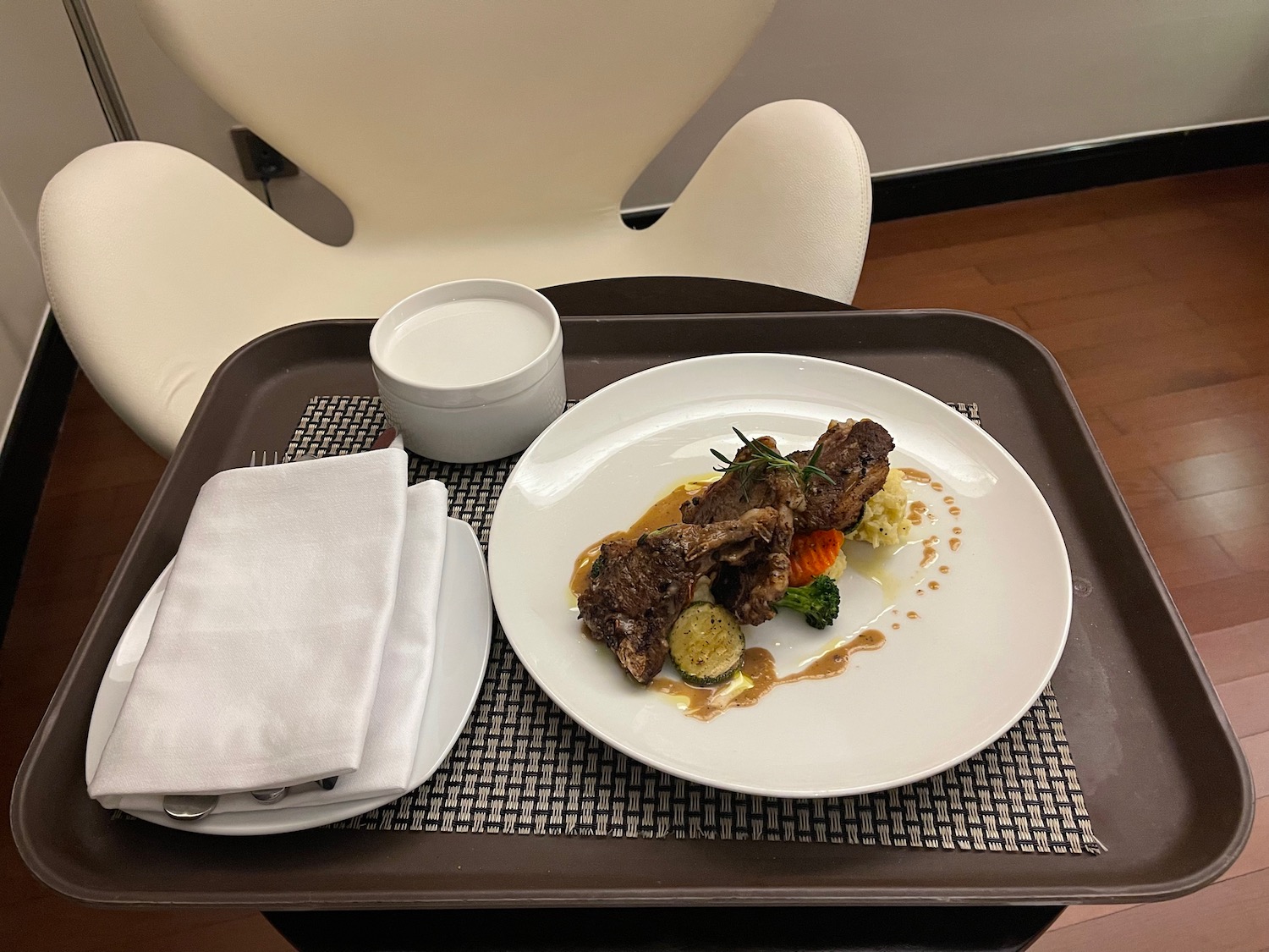 a plate of meat and vegetables on a tray