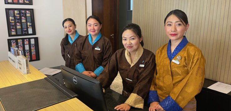 a group of women standing in front of a computer