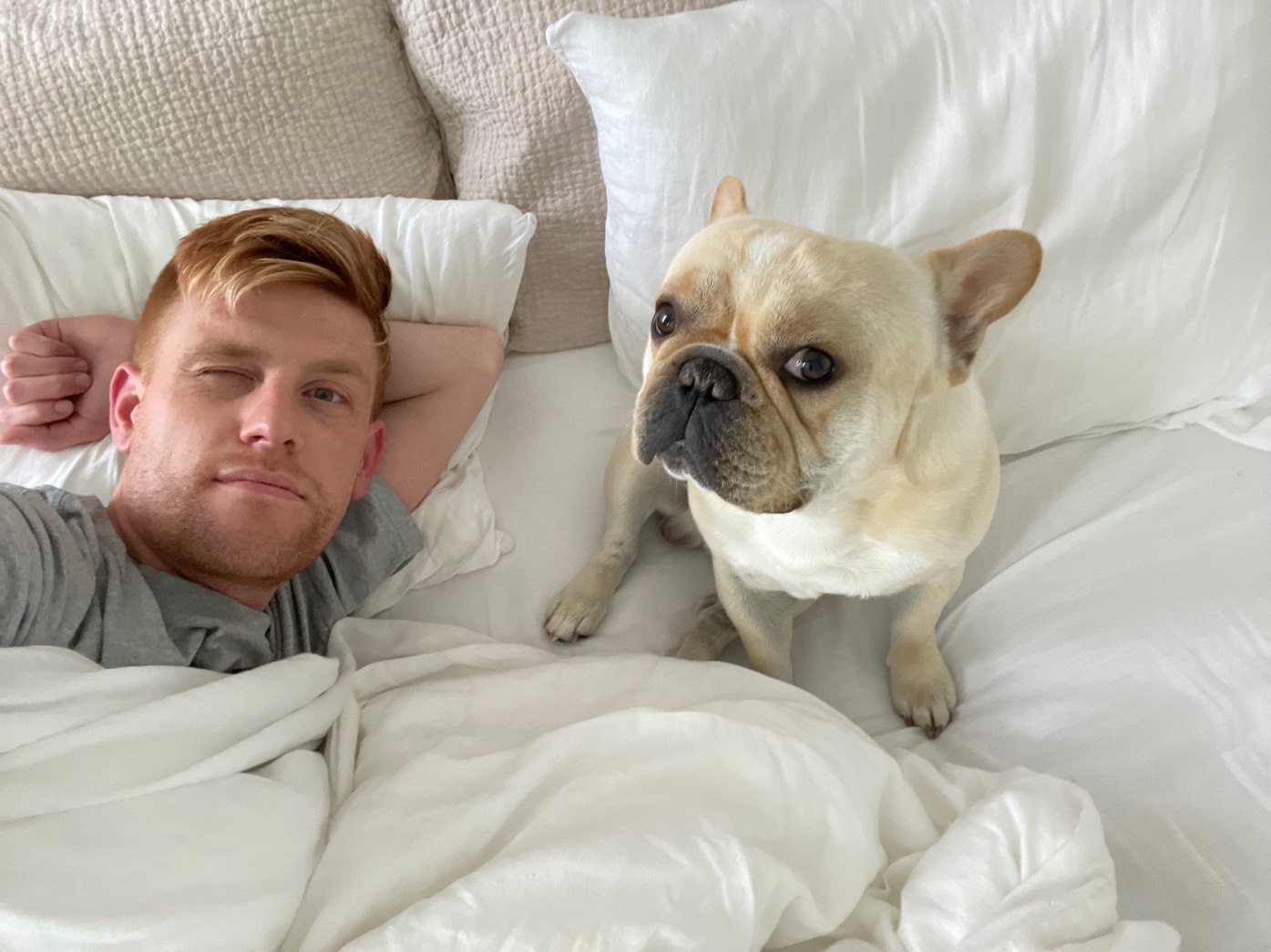 a man lying in bed with a dog