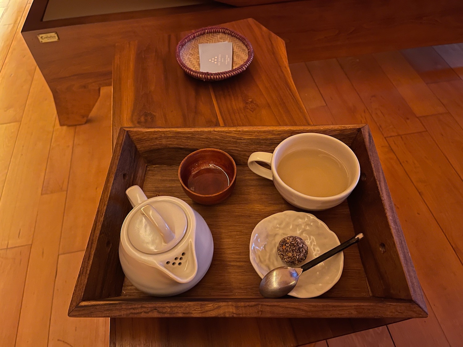 a tray with tea cups and teapots on a wooden table