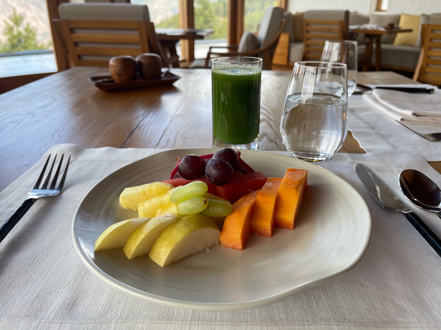 a plate of fruit and a glass of juice on a table