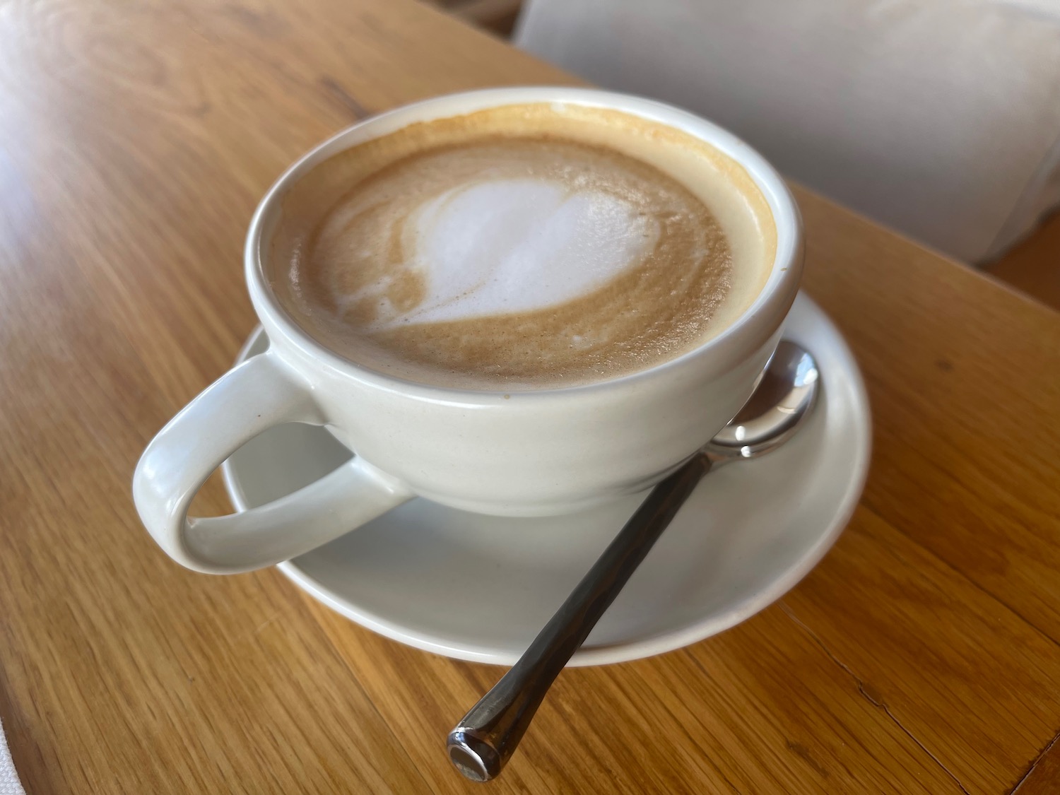 a cup of coffee on a saucer with a spoon