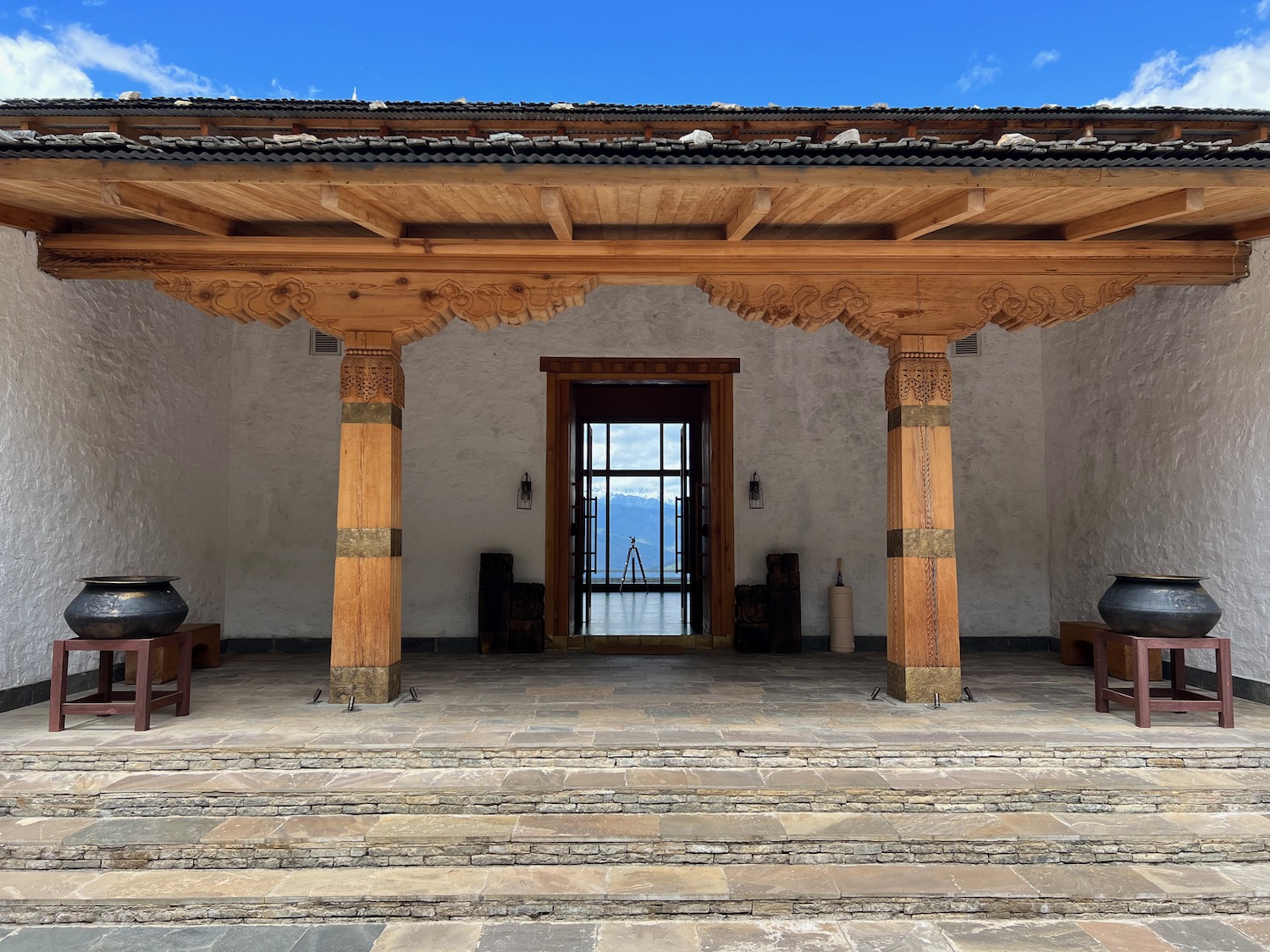 a stone walkway with pillars and a door