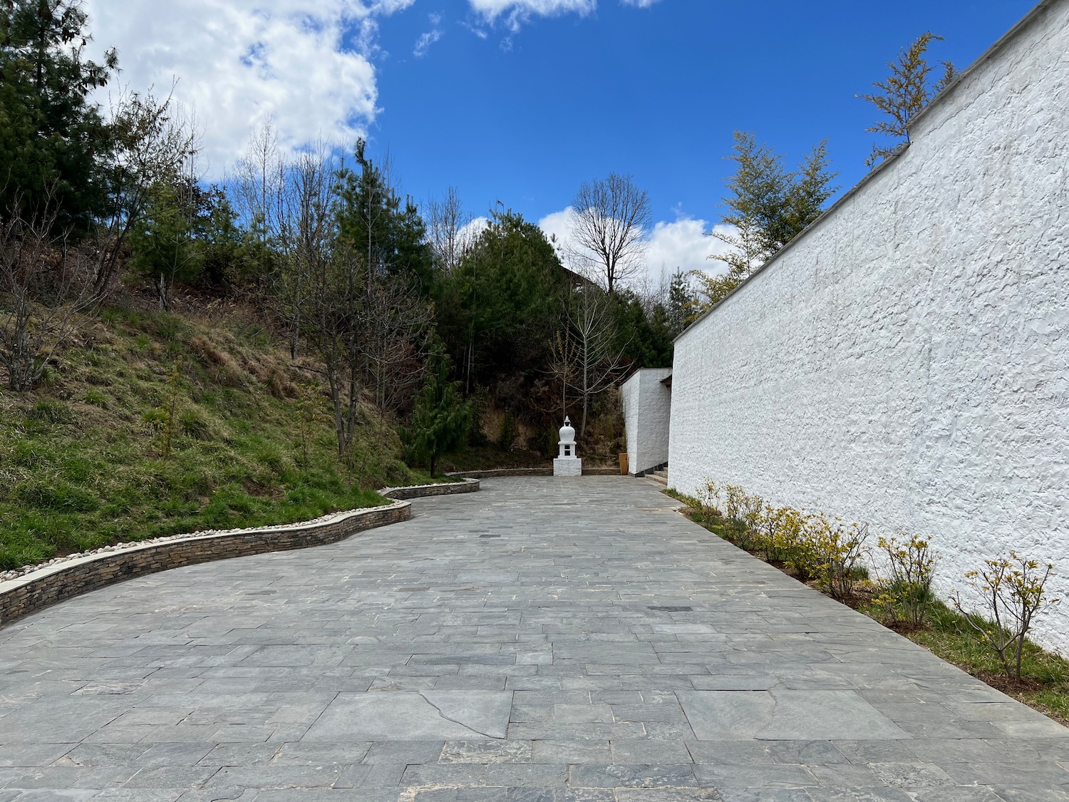 a stone path with a white tower on the side