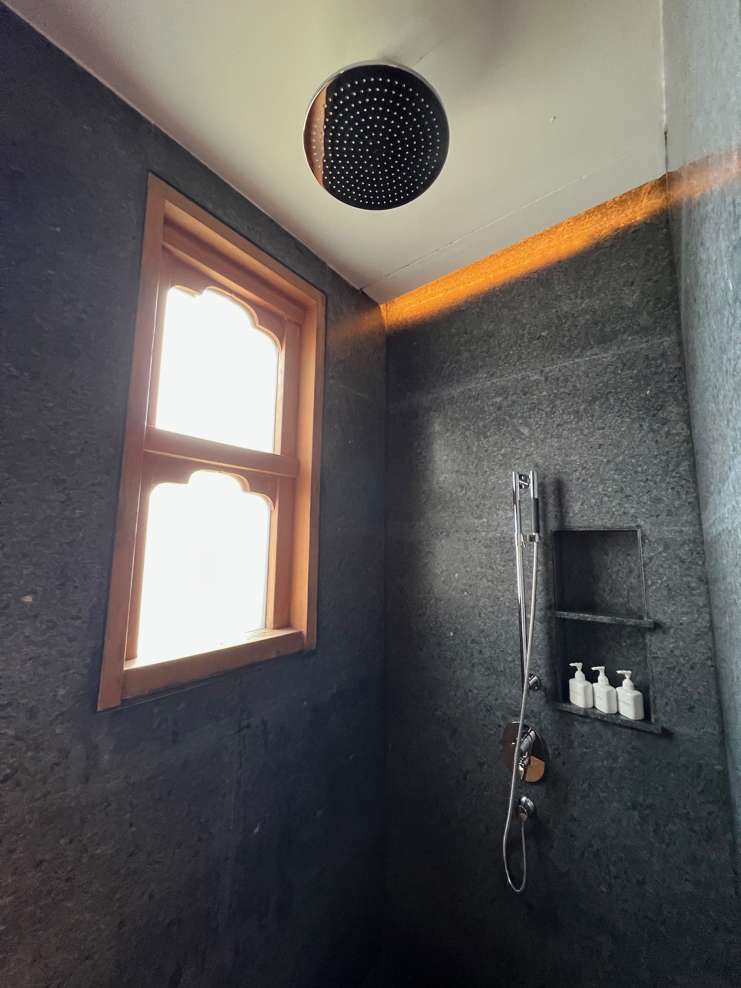 a shower with a light fixture and a window