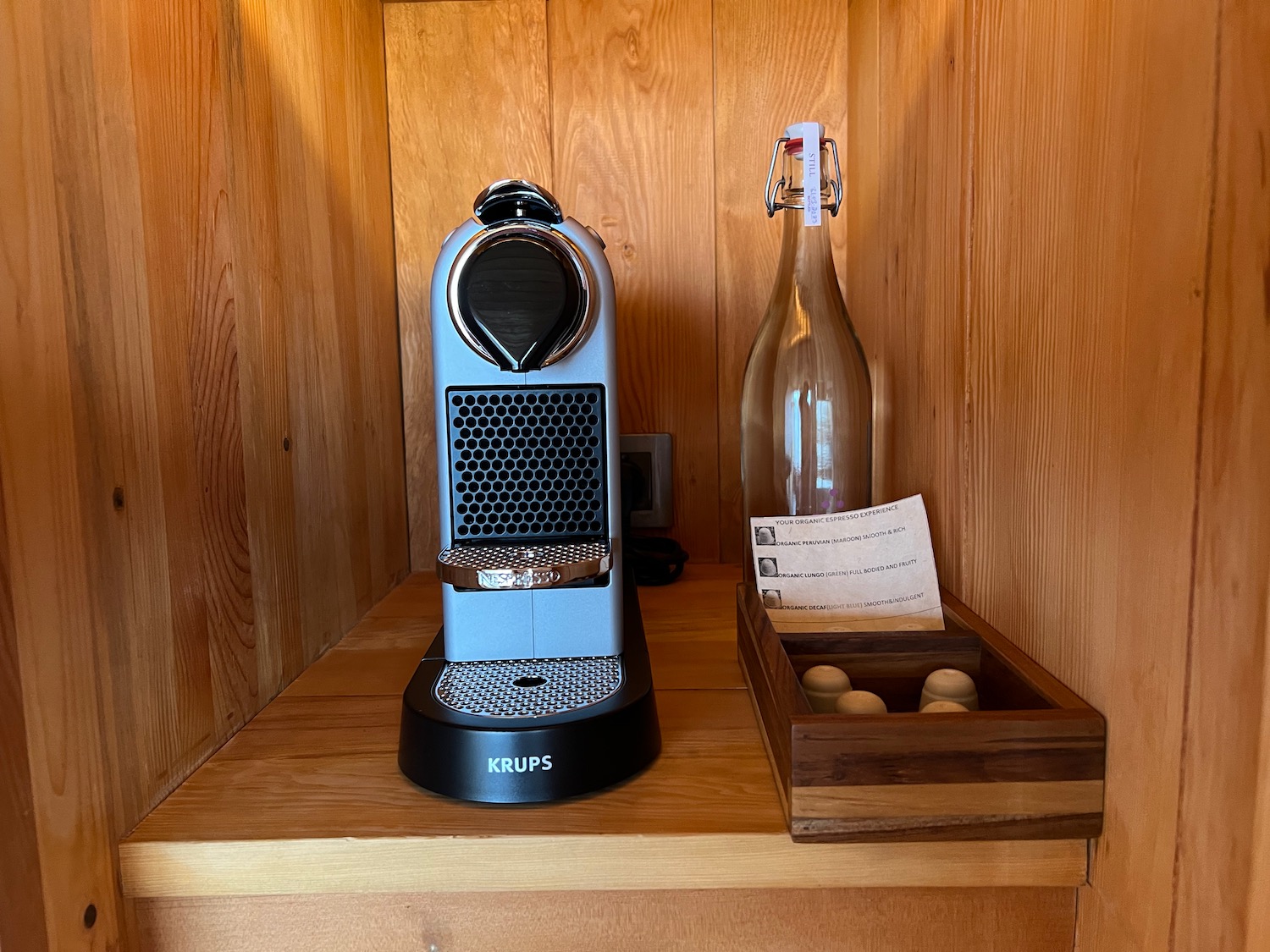 a coffee machine and a bottle on a shelf