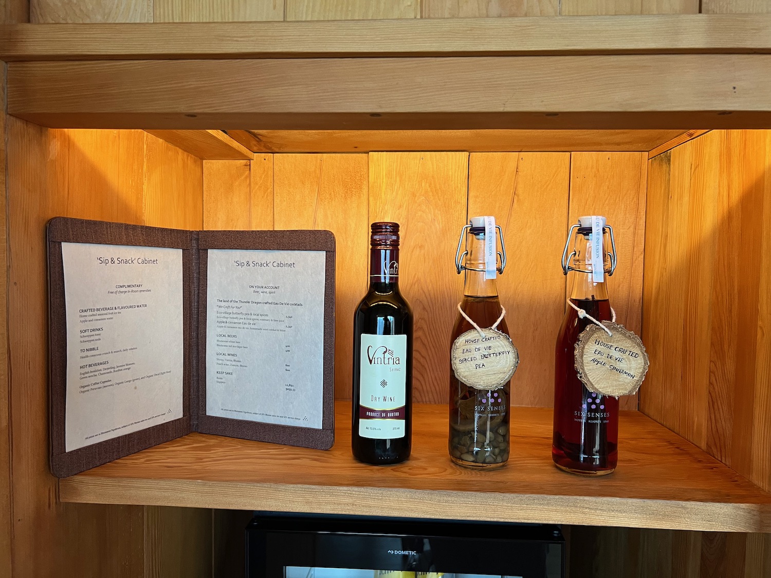 a shelf with bottles of liquid and menu