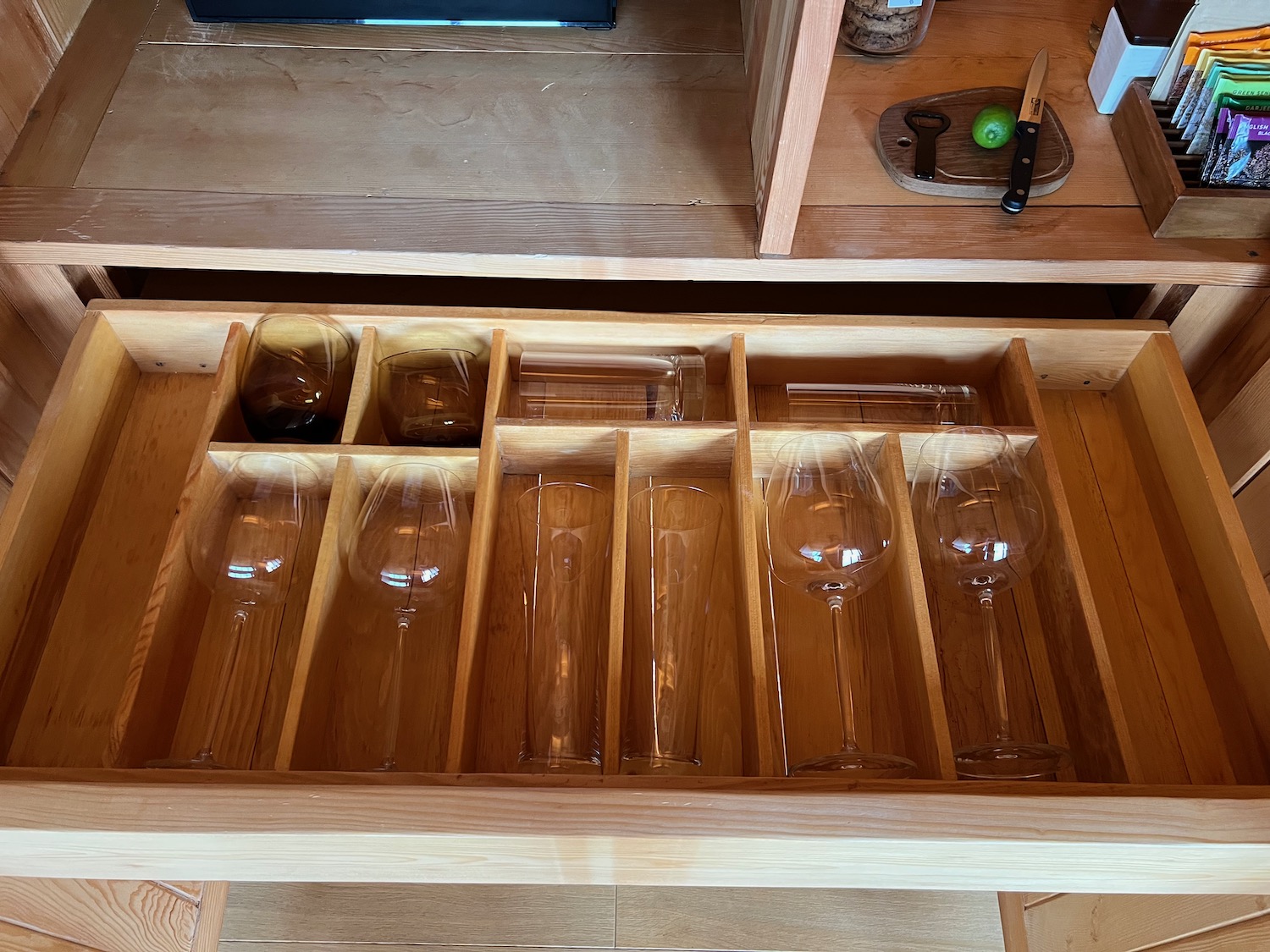 a wooden drawer with wine glasses inside