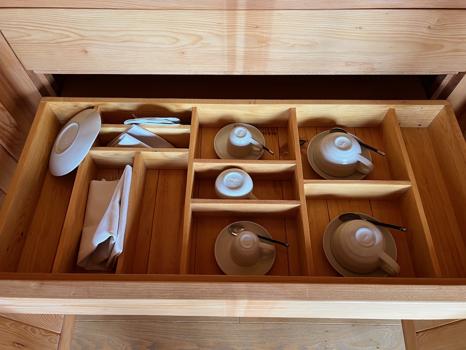 a drawer with teacups and saucers