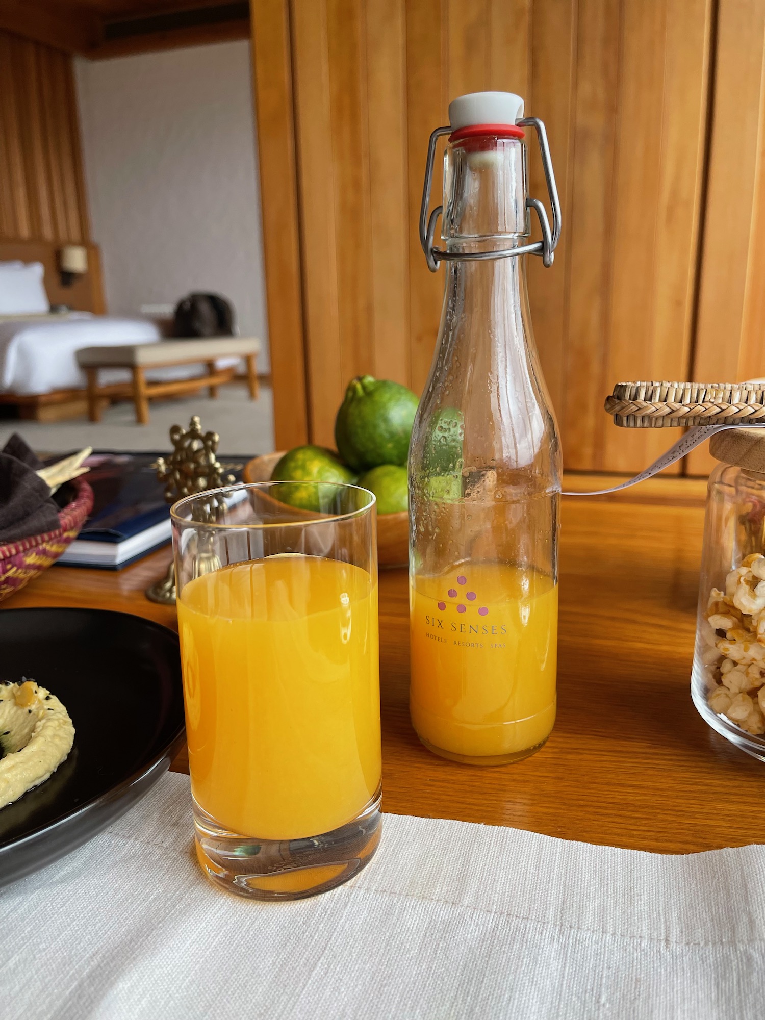 a glass bottle and a glass of orange juice on a table