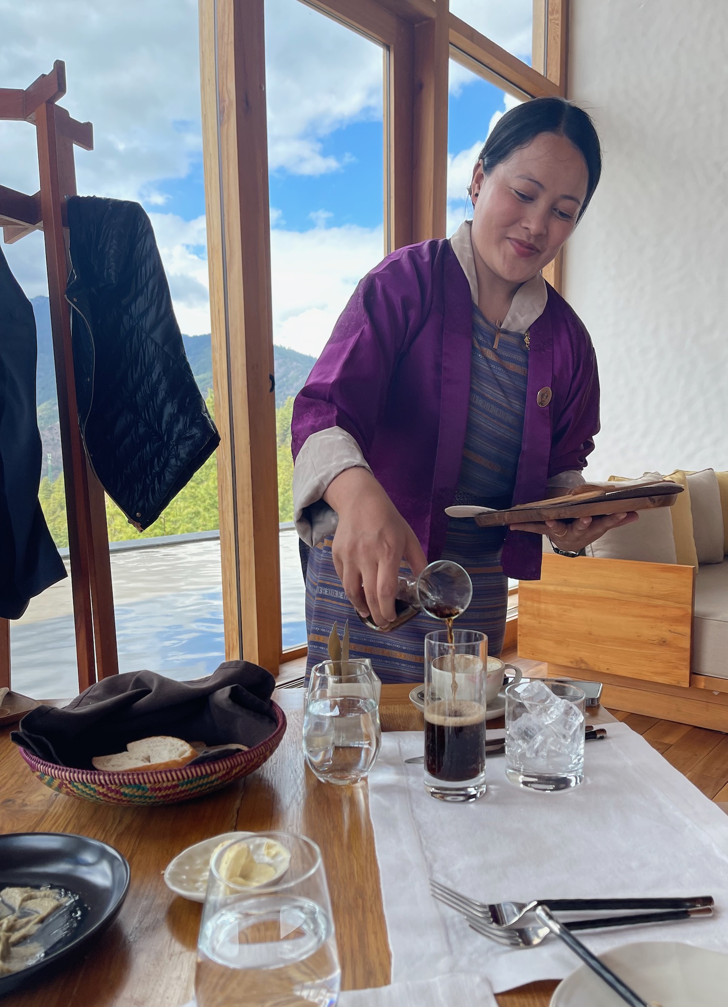 a woman pouring coffee into glasses